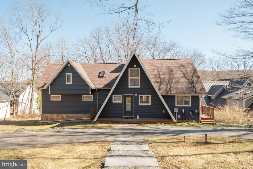 5BR, 3BA lakefront home with a private Type A dock,  1 mile to Wisp! Coveted location on Marsh Hill Rd, you will love 104 ft of wooded waterfront privacy and .63 acres of land. Gently sloped lot with a deep water dock area which offers maximum usage through the entire boating season. This renovated A frame is the perfect blend of vintage Deep Creek with some modern touches. MASSIVE stone fireplace in the living room with vaulted ceilings and exposed beams sure to be a favorite spot overlooking the lake -impressive views and no lack of natural lighting. Unique floor plan, large rec room area on the lower level with walk out to the lake. Spacious wrap-around deck for entertaining and outdoor dining is also a perfect spot for your hot tub with lake views. Extensive hardscaping and parking area added recently, along with a convenient circular driveway. Licensed vacation rental, A Frame of Mind.