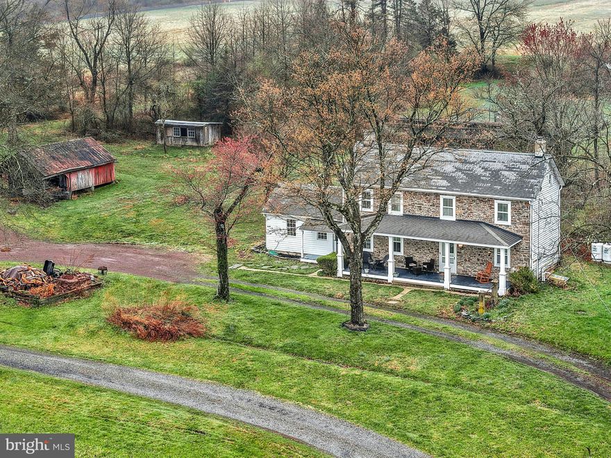 Wide skies and tall trees frame this incredible 12 acre homestead on a quiet country road in Bucks County. 
     Set far back from the road, the classic 1790 stone farmhouse reminds one of a slower, more intentional life. Panoramic views make the covered front porch a lovely place for morning coffee or evening drinks with friends. Inside, the home is cozy, with deep silled windows with rounded cheeks throughout, and a wood burning stove in the living room. The eat-in kitchen is sunny and well-appointed, with room for a table and chairs.  Adjacent, the mudroom and workroom provide storage or hobby space.
     Upstairs, a  primary suite is joined by two additional bedrooms and a hall bath. Access to an unfinished third floor offers an opportunity for additional living space.  Wood floors are found on each level.   The laundry is located in the tidy lower level, along with additional storage space.
     This exceptional property and location presents an unparalleled opportunity which will appeal in a multitude of ways.   As is for a serene rural retreat or as a historic backdrop for expansion and embellishment befitting the location and setting.    Located in the Central Bucks School District.