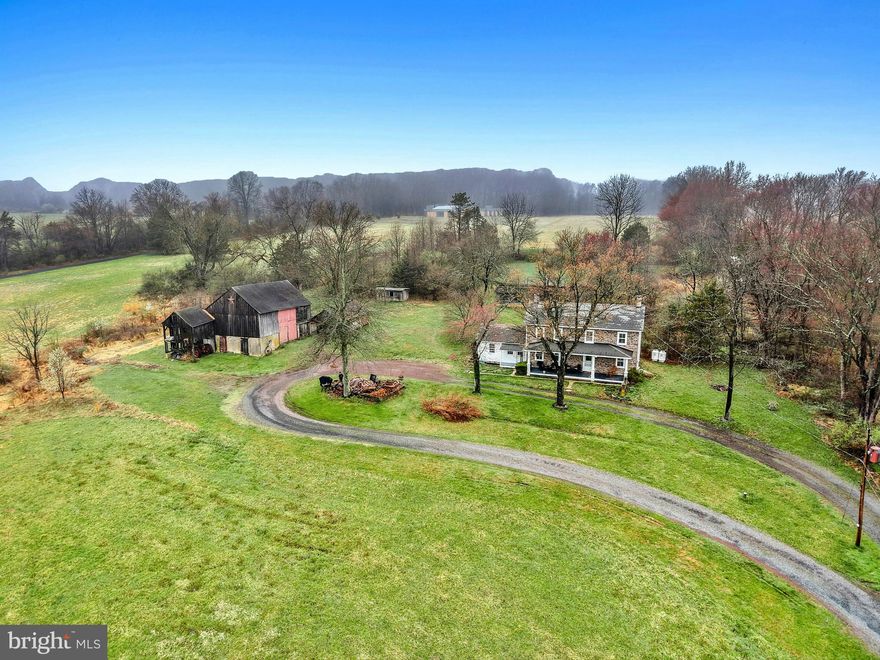 Wide skies and tall trees frame this incredible 12 acre homestead on a quiet country road in Bucks County. 
     Set far back from the road, the classic 1790 stone farmhouse reminds one of a slower, more intentional life. Panoramic views make the covered front porch a lovely place for morning coffee or evening drinks with friends. Inside, the home is cozy, with deep silled windows with rounded cheeks throughout, and a wood burning stove in the living room. The eat-in kitchen is sunny and well-appointed, with room for a table and chairs.  Adjacent, the mudroom and workroom provide storage or hobby space.
     Upstairs, a  primary suite is joined by two additional bedrooms and a hall bath. Access to an unfinished third floor offers an opportunity for additional living space.  Wood floors are found on each level.   The laundry is located in the tidy lower level, along with additional storage space.
     This exceptional property and location presents an unparalleled opportunity which will appeal in a multitude of ways.   As is for a serene rural retreat or as a historic backdrop for expansion and embellishment befitting the location and setting.    Located in the Central Bucks School District.