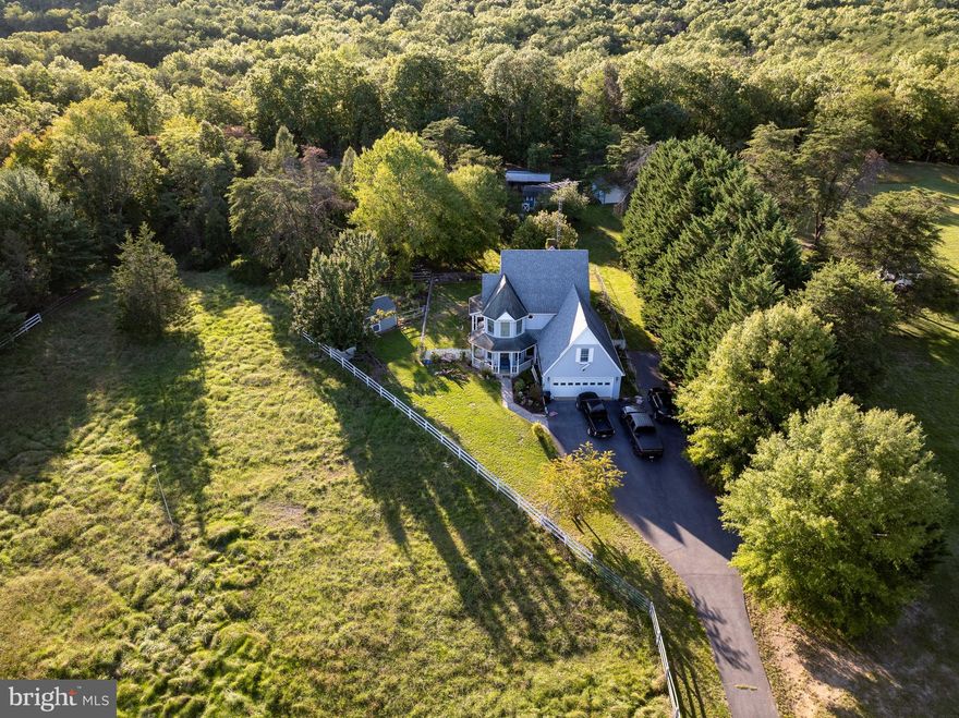 Peaceful and Quiet surroundings with this Victorian style farm house.  Board fenced  for horses in addition to 2 stall barn, run in shed and storage buildings for hay and other equipment.  Great layout with full bath on the main level.  Off of the kitchen and dining room is access to a wrap around screened in porch.  Living room has a pellet stove with stone accents.  Large laundry room with  sink off of the entry from garage. Upstairs you'll find 2 large bedrooms and the Primary.  The Primary bedroom features bay window for the mountain views, full bath, large walk in closet and a bonus space for use as craft room or office.  Full unfinished basement with bilco access. So much potential in this cute farmette. Seller is installing two new heat pumps prior to settlement.
