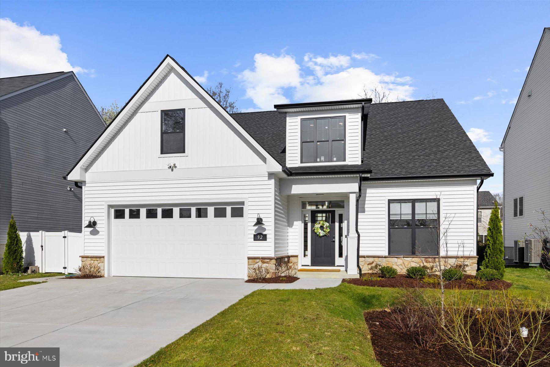 Built in 2023, this custom designed 4 bedroom, 3 bathroom home offers 2,865 square feet of carefully curated living space. From the moment you enter, you're welcomed by clean architectural lines, warm finishes, and a floor plan designed for both comfort and flexibility. The main level features a spacious primary suite with a walk-in closet and a luxurious en suite bath, complete with an 8 foot glass enclosed shower, dual Delta Galeon shower heads, radiant heated tile flooring, and matte black fixtures. Also on the main level is a second bedroom with direct access to a full bath, a light-filled living room with a propane fireplace, a dedicated dining area, a thoughtfully designed chef’s kitchen with high-end finishes, a full laundry room, interior access to the garage, a coat closet, and walkout access to the backyard.
Wide plank Shaw Elegance White Oak flooring runs throughout the main level and second floor landing, paired with 5 inch Craftsman baseboards for a clean and timeless aesthetic. The kitchen was designed for both everyday living and entertaining, anchored by a 9 foot island with Level 8 Virginia Mist honed granite, and equipped with GE stainless appliances, a separate gas cooktop with a pot filler overtop and wall oven, a Delta Antoni chrome faucet, and curated lighting selections from CB2 and Industry West. Custom shiplap accents add warmth and texture in both the kitchen and dining areas.
Upstairs, Berber hybrid carpet brings softness to the additional bedrooms and loft. Ceramic tile finishes all bathrooms and the laundry room. Additional interior features include spray foam insulation, solid core interior doors, black Schlage hardware, a tankless water heater, and custom lighting throughout. The oversized 22 by 27 foot garage offers ample space for storage, hobbies, or workshop needs.
Outside, the home features upgraded clapboard vinyl siding, Craftsman-style windows, a floating Trex rear deck with integrated lighting, a fenced backyard with vinyl fencing and a fully sodded and irrigated lawn.
Ideally located near Fort Meade with quick access to MD 32, I 97, and BWI, this home offers a convenient commute to Annapolis, Baltimore, and Washington DC. Nearby you can find beloved local dining and shops, along with parks, trails, and outdoor spaces just minutes away.