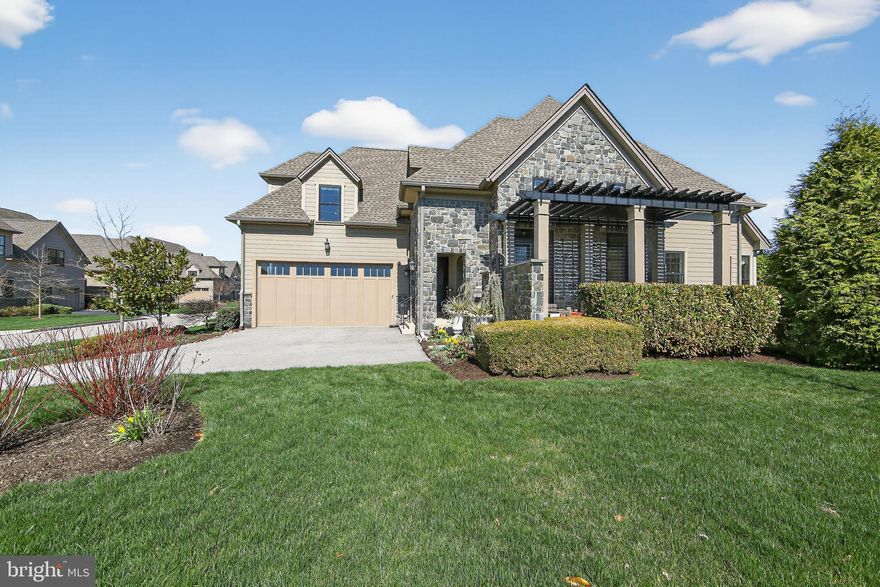 Experience elevated, low-maintenance living in this exceptional former model home, thoughtfully designed with premium finishes and luxury upgrades throughout. The highly sought-after Benezet model is the only floor plan in the community to feature a first-floor primary suite— with just eight of these exceptional homes available in the entire development. Ideally positioned on a corner lot adjacent to the clubhouse, this residence offers rare tranquility with no neighboring homes overlooking the property and an abundance of natural sunlight streaming through every room. One of the home’s most remarkable features is its seamless indoor-outdoor lifestyle. Enjoy two spacious decks where you can follow the sun throughout the day. The covered side porch, a unique addition approved by the HOA, overlooks the formally landscaped, private garden which further enhances the home’s peaceful setting. Inside, the main level showcases soaring ceilings, rich hardwood flooring, and the desirable first-floor primary bedroom suite. The spa-inspired bathroom features dual vanities, an upgraded shower, separate water closet, and plenty of storage. An oversized walk-in closet completes this room. The gourmet kitchen is outfitted with top-tier cabinetry, designer tile, premium appliances, and an impressive 7-foot Viking wine refrigerator. A large center island opens to the bright living room with a cozy fireplace, creating an effortless flow for everyday living and gatherings alike.  Upstairs, an additional two generously sized bedrooms each offer walk-in closets and private en-suite baths. A loft area, allowing more flex space, rounds out this level.  The expansive lower level provides exceptional flexibility, including a comfortable TV lounge currently used as a guest space, a fully equipped gym, and ample additional square footage (850 sf) with the potential to create a fourth bedroom. Storage is plentiful throughout. Located just steps from the clubhouse, mailboxes, and resort-style pool — yet thoughtfully positioned far from the freight train tracks at the rear of the community — this home delivers both convenience and serenity. Residents of The Reserve at Creekside enjoy access to a spectacular 4,500-square-foot clubhouse, fitness center, and outdoor pool, with an HOA that covers lawn care, snow removal, and common area maintenance. Minutes from Wissahickon Valley Park, Fort Washington Park, premier golf courses, shopping, dining, the PA Turnpike, and the Fort Washington train station, this location balances natural beauty with everyday accessibility. This is a rare opportunity to own one of the community’s most desirable homes, combining model-quality craftsmanship, privacy, and refined comfort.