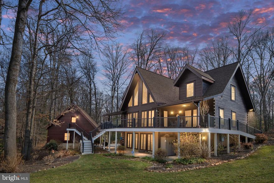 Welcome to your private waterfront retreat on the public side of  Lake Anna in sought after Tara Woods community, where every day feels like a getaway and lake living becomes your lifestyle.
Tucked away on two combined lots totaling over 2 acres, this meticulously maintained Jim Barna log home is a rare blend of craftsmanship, comfort, and connection to the water. Built with impressive 6x12 hewn dovetail construction in classic post-and-beam construction, the home radiates warmth and authenticity from the moment you arrive. A manicured approach, with mature trees and lush landscaping, welcomes you in with a paver-edged circular drive and generous car park—setting the tone for the thoughtful details found throughout.
Step inside and be immediately drawn to the soaring cathedral ceilings and long, tranquil views of the lake. The great room is anchored by a stunning stone fireplace with gas logs, flanked by custom built-ins, and opens seamlessly to the expansive rear deck—perfect for morning coffee at sunrise or evening gatherings under the stars. The deck and front porch were upgraded in 2025 with composite decking and sleek aluminum railing, offering beauty with low maintenance.

The kitchen has been stylishly refreshed with painted cabinetry, elegant quartz countertops, a newer refrigerator, and a cooktop island with breakfast bar seating—ideal for casual meals and conversation. A separate dining room captures peaceful lake views, making every dinner feel special.

The main-level primary suite offers a serene escape with lake views, French door access to the rear deck, a walk-in closet with built-ins, and a private bath. Upstairs, a charming loft overlooks the great room and leads to two spacious bedrooms connected by a Jack-and-Jill bath featuring dual vanities and separate water closets—designed for comfort and convenience.

The lower level was made for entertaining, complete with a family room, hickory cabinetry, a bar with refrigerator, and a large finished room currently used as a bedroom with its own full bath—ideal for guests after a full day on the water.

Outside, the lifestyle truly shines. The gently sloping, level lot makes access to the lake effortless. Wide open views but quiet cove.  An irrigation system drawing from lake water keeps the grounds vibrant all season long. Down at the shoreline, your single-slip boathouse offers excellent water depth, built-in storage, a heavy-duty boat lift, jet ski lift, retractable shade, and ample decking for lakeside gatherings. The roof was replaced in 2023, as was the home’s roof—providing peace of mind for years to come.

With an attached garage plus an oversized two-story detached garage ready to house all your lake toys, there’s room for everything—and everyone.

This is more than a home. It’s early morning paddles, afternoon boat rides, sunset cruises, and evenings by the fire. It’s the sound of water against the dock and laughter echoing across the deck.

It’s the lake life—elevated.