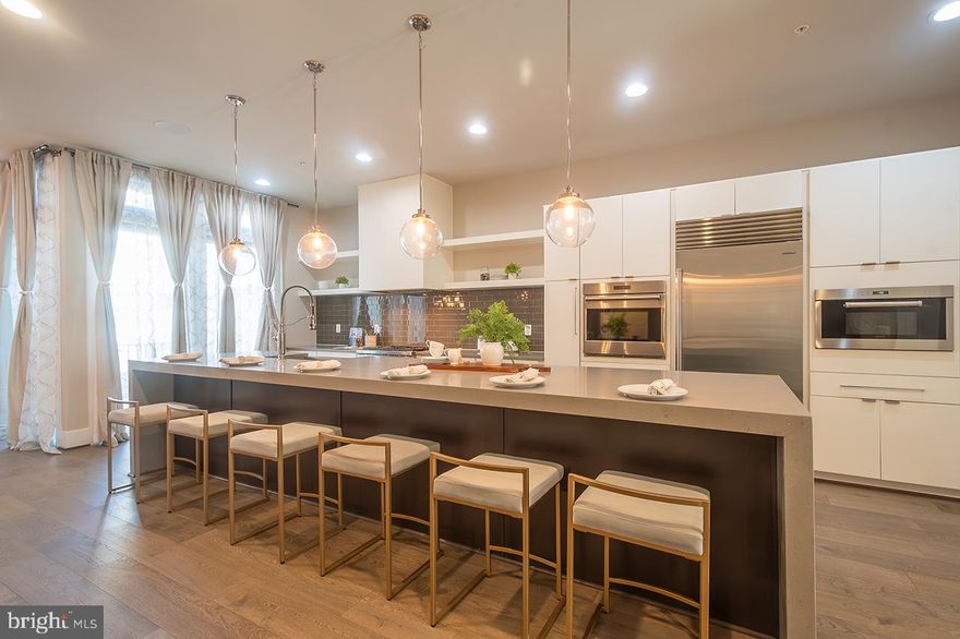 Welcome home to a stunning luxury four-level elevator townhouse that redefines modern living with comfortable elegance and sophistication. Nestled in Downtown One Loudoun - a highly sought-after and walkable community featuring abundant shops, fabulous and fun restaurants, the local Farmer's market, community events, and more - this residence boasts a seamless blend of upscale design and comfortable living spaces, making it a perfect sanctuary for those who appreciate top quality,  exceptional style, and the convenience of a low-maintenance home!

As you step inside, you’ll enjoy the detail and an array of transitional upgrades that elevate this home above the ordinary.  You'll notice the quality of this construction at every turn and love the 10-foot ceilings on the first three levels (9 feet on the Upper II level). 

The lower level of this home was designed with function and convenience in mind. The distinctive vestibule and family room are perfect for welcoming guests. This level has a mud room with storage and closet space, a convenient powder room, and a two-car garage with an extra refrigerator.  The elevator may be called from here and services all four levels of this home.  

The home's main level radiates a sense of refined comfort from the state-of-the-art kitchen equipped with high-end Wolf, Sub Zero, and Asko appliances. The inviting oversized waterfall quartz island is central to this level and is open to the generously sized Great Room. The whimsical and bright Dining Room is on the back of the house next to the Balcony, which has a built-in gas line for a grill. 

The Upper level houses the Primary Suite with a fabulous Luxury Bath - featuring a combination walk-in shower and soaking tub, dual sinks with quartz, a water closet - big walk-in closet, and a lovely Balcony for added fresh air.  There are also two generously sized bedrooms, a hall Bath, and a Laundry Room with a utility sink on this level!  

Venture to the top level for the fourth Bedroom, third full Bath, and an open Loft area for added living space, and discover your private Rooftop Terrace—a true gem featuring an outdoor gas fireplace, perfect for cozy evenings under the stars or entertaining friends and family. 

There's so much to enjoy right around this home as well!  In addition to the ONE LOUDOUN downtown area, you'll enjoy the clubhouse with an outdoor pool and tennis, miles of walkways and trails, and the central park with the Barn for abundant community activities!  You're a short distance from the Washington Commander's practice field and just about 15 minutes away from Dulles Airport.  

Experience the ultimate luxury living in this extraordinary townhouse, where style, convenience, and community create an enviable lifestyle!  You've got to come see it to feel it!  Open this Sunday, 1-3!