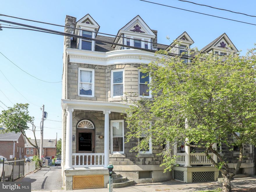 Looking for a live/work home in downtown Martinsburg?  Look no further!  This historic Victorian style, concrete rock face block-sided property is zoned for both office and residential use, offering the best of both worlds.  Enjoy the convenience of a central location in town and sweeping side porches on the main and upper levels, as well as a backyard to enjoy cool breezes.  Inside, soak in the beauty of the historic hardwood floors, tall baseboards, and elaborate trim and molding designs throughout the home from the Queen Anne era.  The front door leads you to a beautiful front stairwell and pocket doors to the front living room.  The main level features a front living room, currently used as an office, with a dual mantel and two sets of working pocket doors leading to the large dining room with built-in China cabinet, and hallway to the full bath and kitchen.  The updated kitchen has modern appliances, including a brand-new dishwasher and stove, and opens to a small porch, parking area, and back yard behind the parking area with gardens and alfresco dining area.  Upstairs, you'll find three nicely sized bedrooms, a full bath with water closet, and a large additional living room.  The third level offers even more possibilities with another finished bedroom and large storage area/attic that could be updated for even more finished space.  The unfinished basement is also dry and great for storage.  Live entirely in this spacious, well-maintained home, or occupy just the upstairs and work in the front as you get your business started or make it all an office.  The choice and possibilities are yours!  **Updated electrical and plumbing.**   Don't miss this opportunity to invest in the perfect live/work property in the heart of downtown Martinsburg!