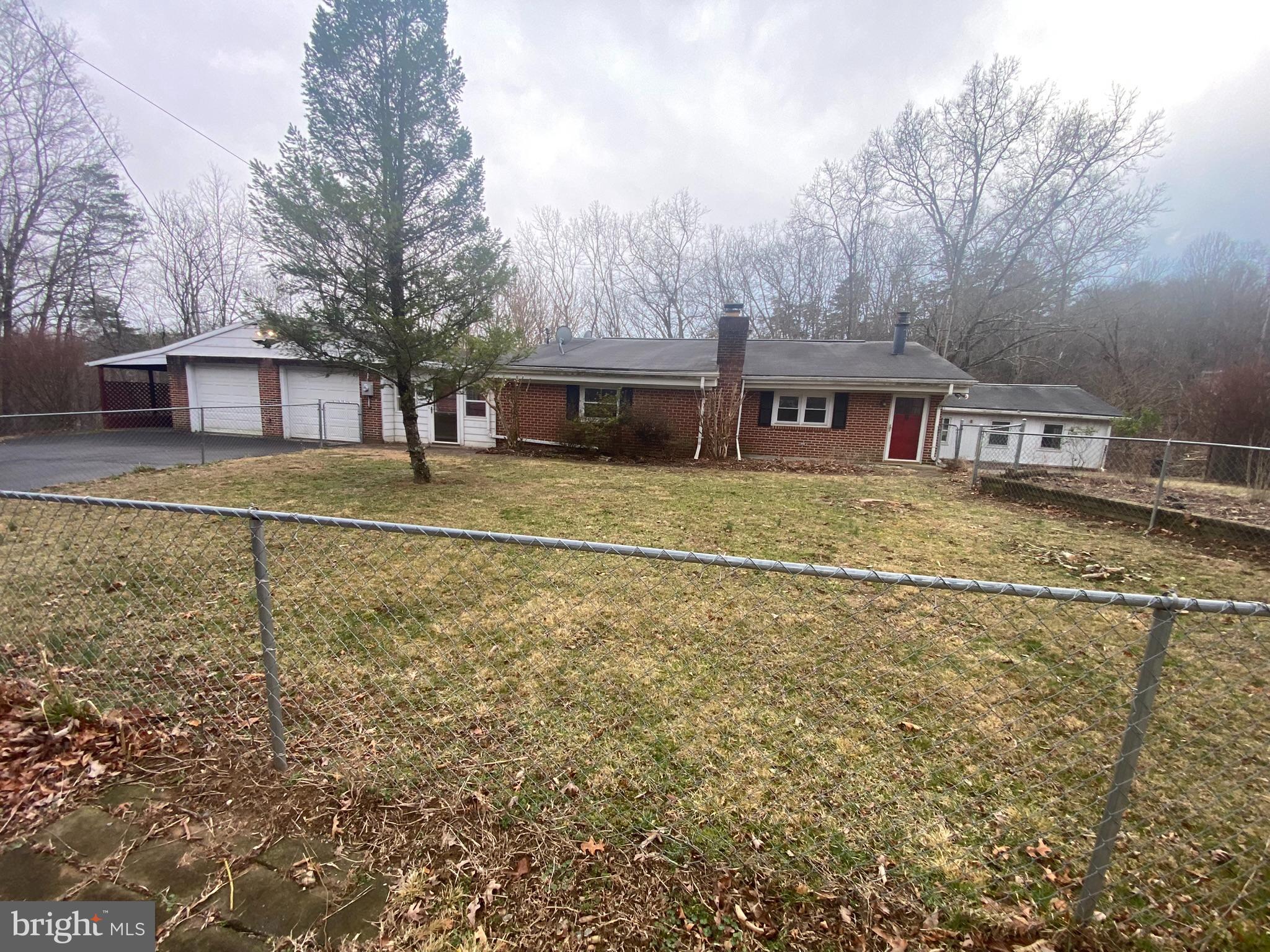 This 3 bedroom, 2 bath large rancher sits on OVER 2 acres! An attached 2 car garage keeps your car (and you) out of the weather plus a carport next to that. This space could also be used for storage or an at home workshop. The living room is spacious with plenty of room for entertaining. Kitchen is a great size and opens to the breakfast nook. Off of the breakfast room is a large, carpeted bedroom. Bedroom 2 features laminate flooring. A hall bath includes a tub/shower with glass surround. The primary bedroom features vinyl floors and a fireplace with woodstove insert. It opens to the large sunroom. Bathroom 2 features a pedestal sink and walk-in shower. There is a large, carpeted family room with another woodstove and cathedral ceiling. This home has the space you need and the land you want! Call for more info today!