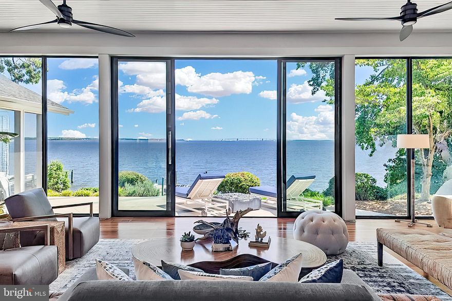 Life will never be the same.  This slick and sleek coastal contemporary is beautifully designed for optimal waterfront living.  With six bedrooms (FIVE ensuites), six full baths and one half bath, waterviews are visible from nearly all living spaces and bedrooms (and three bathrooms, to be fair).  Witness the walls of windows on the first level, facing the Chesapeake Bay to the East and Severn River to the Northwest; one will never be bored with the marvelously incessant theatre of watercraft and nature.   Enjoy morning coffee out on the open air patio, down at the pier, or in the large, screened porch.  If weather is uncooperative, stretch out in the massive open living area, or retreat to one of two second floor water-facing rooms (one perfect for sitting room/office) to take in a new perspective.  This home was fully renovated in 2017, sporting gorgeous custom light cherry 5" wood floors on the first and second level and showcasing unique custom, open staircases with black cable handrail system.  There are two primary bedroom ensuites; one on the first floor featuring concrete shower floor, bathroom floor and cast concrete countertop.  With generous, custom closets and oversized windows featured in each room, both residents and guests are guaranteed to render a five star rating for their stay and experience.   This property is one block from 70 acres of walking trails and two blocks from the community beach, playground, picnic pavilion and firepit.