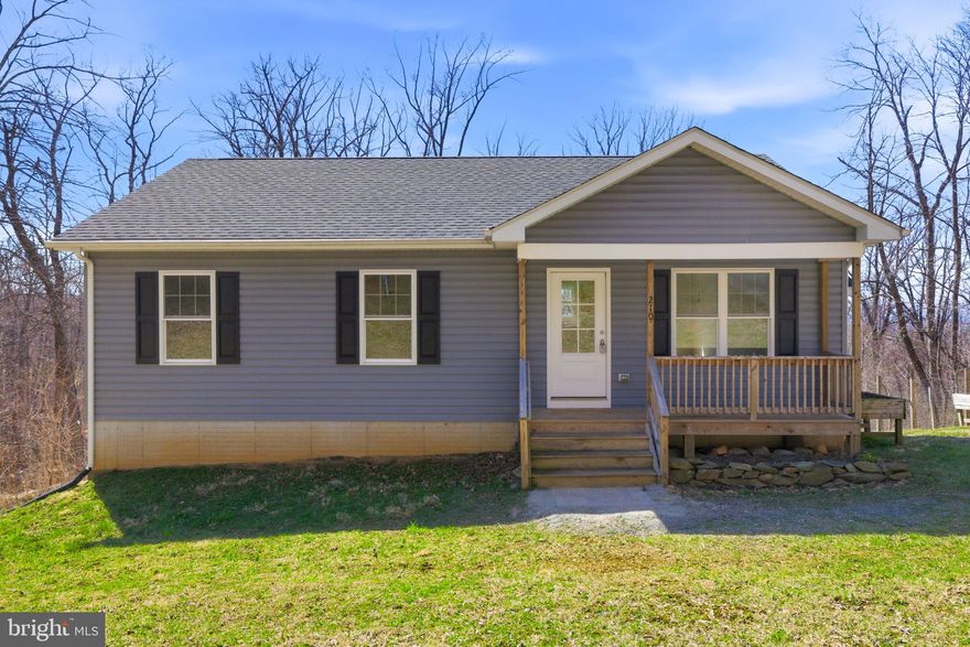 Tucked away on a peaceful, wooded .39-acre lot, this charming ranch offers the kind of quiet mountain living that instantly makes you exhale. Surrounded by nature , this home is a perfect retreat from the pace of everyday life — yet still conveniently close to commuter routes. The light-filled, open floor plan is designed for both connection and comfort. The warm stone fireplace creates a cozy focal point, while the beautifully appointed kitchen invites you to linger — featuring quartz countertops, stainless steel appliances, a center island, and a dining area perfect for everyday meals or hosting friends and family. Imagine morning coffee or sunset dinners on the spacious rear deck overlooking breathtaking mountain views. The inviting front porch offers another spot to unwind and take in the sounds of nature.  The primary bedroom suite has its own en-suite bath, while two additional bedrooms and a full hall bath offer flexibility. Downstairs, the unfinished walk-out basement presents future possibilities with windows that bring in natural light and a rough-in already in place for a future bathroom. Laundry is currently conveniently located on the main level but can easily be relocated to the basement if desired.  Residents enjoy access to two private lakes and riverfront common areas, making this a true haven for outdoor enthusiasts who love fishing, kayaking, hiking, or simply being immersed in the beauty of the mountains. If you’ve been dreaming of a home where nature, comfort, and possibility come together, this special property is ready to welcome you.