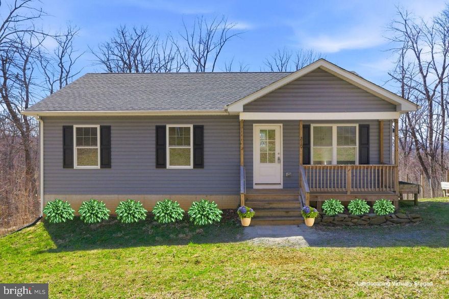 OPEN HOUSE, Saturday, April 11th 11AM to 2PM .   Tucked away on a peaceful, wooded .39-acre lot, this charming ranch offers the kind of quiet mountain living that instantly makes you exhale. Surrounded by nature , this home is a perfect retreat from the pace of everyday life — yet still conveniently close to commuter routes. The light-filled, open floor plan is designed for both connection and comfort. The warm stone fireplace creates a cozy focal point, while the beautifully appointed kitchen invites you to linger — featuring quartz countertops, stainless steel appliances, a center island, and a dining area perfect for everyday meals or hosting friends and family. Imagine morning coffee or sunset dinners on the spacious rear deck overlooking breathtaking mountain views. The inviting front porch offers another spot to unwind and take in the sounds of nature.  The primary bedroom suite has its own en-suite bath, while two additional bedrooms and a full hall bath offer flexibility. Downstairs, the unfinished walk-out basement presents future possibilities with windows that bring in natural light and a rough-in already in place for a future bathroom. Laundry is currently conveniently located on the main level but can easily be relocated to the basement if desired.  Residents enjoy access to two private lakes and riverfront common areas, making this a true haven for outdoor enthusiasts who love fishing, kayaking, hiking, or simply being immersed in the beauty of the mountains. If you’ve been dreaming of a home where nature, comfort, and possibility come together, this special property is ready to welcome you.