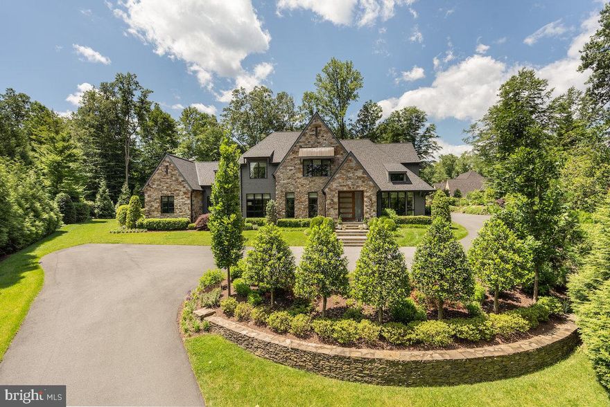 ***call listing agents for information on the details of the final transaction price in order to have the accurate market value****

Privately sited on a gated one-acre lot in Langley Forest, this breathtaking 6BR, 11,700+ SF stone and cedar contemporary Tudor was built by Artisan Builders in 2020 and has been further customized since then. Impeccable landscaping, unbelievable pool and pool house, boulder gardens, evergreen privacy fencing, a motor court, and a 4-car garage all come together to deliver a level of serene luxury reserved for Hamptons-style hideaways.

Interior highlights include European white oak floors, a walnut-detailed fireplace, vaulted ceilings with wood beams, a butler’s pantry, and a Lobkovich designed kitchen with dual islands, top-tier appliances, and a breakfast area. Bifolding atrium doors open to a light-filled screened porch with views of the resort-like outdoor entertaining and living space.

The main-level primary suite offers vaulted ceilings, a designer chandelier, dual dressing rooms, and a spa bath with radiant heat. Upstairs are 3 bedroom suites, a lounge, and a walk-in linen closet. A separate guest suite sits off a private side foyer.

The lower level features a custom white oak bar, golf simulator/theater room, oversized & completely mirrored gym worthy of a professional athlete, large family room with fireplace, guest suite, and multiple baths. The outdoor space includes a  +/-1,017 sqft pool house, copper-ion pool, travertine patio, outdoor kitchen with Viking grill, dining area, and a full pool bath.

Smart systems include Lutron, Sonos, landscape irrigation and lighting, full security system, whole-house generator, etc. A rare turnkey offering in one of McLean’s most prestigious neighborhoods.