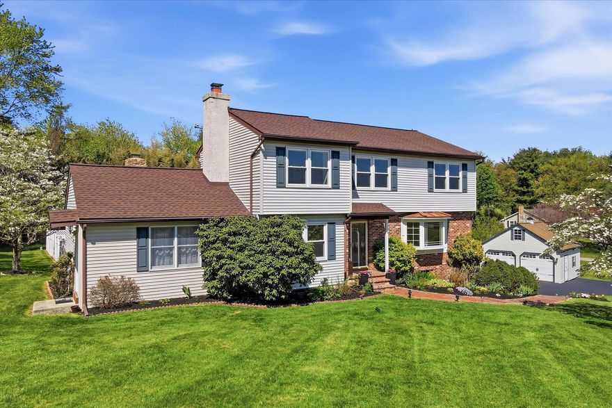 Positioned on a picturesque 1-acre lot directly across from a scenic horse farm, this beautifully maintained property offers the perfect blend of charm, functionality, and outdoor living. A freshly re-asphalted (2019) and sealed driveway leads to a welcoming front entrance, highlighted by a brick paver walkway, fresh landscaping, covered stoop, and beautiful wood door. Inside, a traditional floor plan features oak hardwood floors and is fresh paint throughout. The spacious front room, filled with natural light from a large bay window, offers flexibility as a living or dining space while capturing peaceful countryside views. The expanded custom kitchen (2003), refreshed with repainted cabinetry in 2023, serves as the heart of the home with a large center island, granite countertops, tile backsplash, recessed lighting, and custom built-ins. Just beyond, a comfortable family room features chair rail detail, built-in shelving, and a tiled wood-burning fireplace with a venting system. Both spaces offer direct access to the show-stopping outdoor living area, an approximately $100,000 investment completed in 2018, featuring a covered, low-maintenance deck with fireplace, pergola, white vinyl railings, and black aluminum spindles, all overlooking the in-ground 8’ pool with brand-new pump, paver surround, and 8’ white vinyl privacy fence. This area also has underground electric that is hot-tub ready.  Spend your days splashing in the pool, and your evenings relaxing by the fire!  Another standout feature of the home is the rare and often sought after main-level in-law/au pair suite addition, offering its own private entrance, bedroom, full bathroom, and kitchen/living area, ideal for extended family or flexible living arrangements.  Upstairs, the original three-bedroom layout is complemented by an additional expansion above the family room, creating a versatile office or craft room and a fourth bedroom with built-in shelving. The full bathroom was tastefully renovated in 2010 with custom tile work, and the main bedroom features a custom feature wall. The finished lower level adds even more living and entertaining space, complete with a wet bar featuring granite counters, kegerator, and corner wine rack, along with wainscoting, crown molding, and built in cabinetry for an elevated feel.  A true entertainer's dream!  A walk-out to the driveway, updated powder room, laundry area, and unfinished storage/workshop space with built-in workbench provide both convenience and practicality. Additional highlights include a high-velocity Unico HVAC system installed in 2016 with central air and heat (baseboard heaters for backup or can be removed), generator hookups, approximately 10 year old roof, vinyl replacement windows, and recently cleaned fireplace and carpets. Completing the property is a detached two-car garage (2011) with attic storage and rear fenced in garden area. A rare opportunity to enjoy privacy, space, versatility, and thoughtful upgrades in a truly picturesque setting.