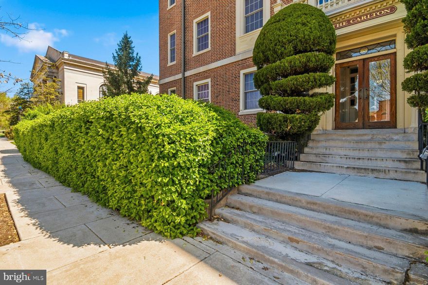 Perched on the top floor of The Carlton, this 3 bedroom residence blends timeless architectural character with modern convenience in one of Baltimore’s most walkable locations—just steps from Johns Hopkins University.
Natural light pours into the approximately 1,100 square feet of living space, highlighting soaring ceilings, rich oak floors. The spacious living area is anchored by an ornamental fireplace, adding warmth and charm, while replacement windows enhance comfort and efficiency throughout. The kitchen retains its original butler’s pantry—an architectural detail that adds both function and historic appeal—while incorporating modern touches including an in-unit washer and dryer for everyday ease. Step outside onto the impressive 32-foot private balcony, offering a rare outdoor retreat with elevated views and abundant sunlight.
Additional features include central air conditioning and a deeded parking space (#7) located behind the building with convenient access off University Parkway, just east of North Charles Street. The monthly condo fee includes heat and water, and residents also enjoy extra storage in the lower level along with a secondary laundry facility.
