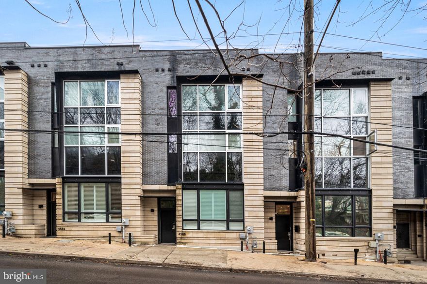 Welcome to 4588 Silverwood Street, a stunning 3,297 sq ft contemporary residence designed by Canno Architecture. This 3-bedroom, 3.5-bath luxury townhome with 5-stop elevator and 2-car attached garage offers refined design, dramatic architectural details, and exceptional indoor-outdoor living in the heart of Manayunk.

A striking custom window wall façade sets the tone for the home’s light-filled interior. The main living level features 11-foot ceilings, wide-plank hardwood floors, recessed lighting, and entire rear wall of La Cantina Accordion style glass doors leading to a deck seamlessly blending the interior with the exterior space. The open-concept layout includes a spacious dining area with seating for 10, sleek chef’s kitchen with Thermador appliance package, six-burner gas range, two oversized islands (one with seating and the other with storage), a wine refrigerator, and abundant cabinetry. The living room showcases a linear gas fireplace, floating shelving, built-in bar area just inviting you and your guests into this serene and welcoming space. 

The entire second floor is dedicated to the primary suite retreat with 10-foot ceilings, floor-to-ceiling windows, dual custom walk-in closets, and a spa-inspired bath featuring two vanities, separate water closets, oversized frameless glass shower, soaking tub, and European finishes by Porcelanosa. 

The third level offers two additional bedrooms with large walk-in closets, two full baths with modern finishes, and a spacious laundry room with full-size Samsung appliances and custom cabinetry.

The pilot house includes a wet bar and wine refrigerator, leading to a two-sided rooftop deck with city views, owner installed wooden hot tub, and mature urban edible garden to grow your favorite herbs and vegetables! 

The lower level provides direct interior access to the 2-car garage (plus third parking space outside), oversized coat closet, and a versatile bonus room currently outfitted as a gym with sauna to enjoy after your workout!

Additional features include tankless hot water heater, Icynene spray foam insulation, high-efficiency dual Carrier HVAC systems, Ecobee thermostats, green roof, and remaining 2 year tax abatement. Conveniently located with easy access to Center City, transportation, highways, and the suburbs.