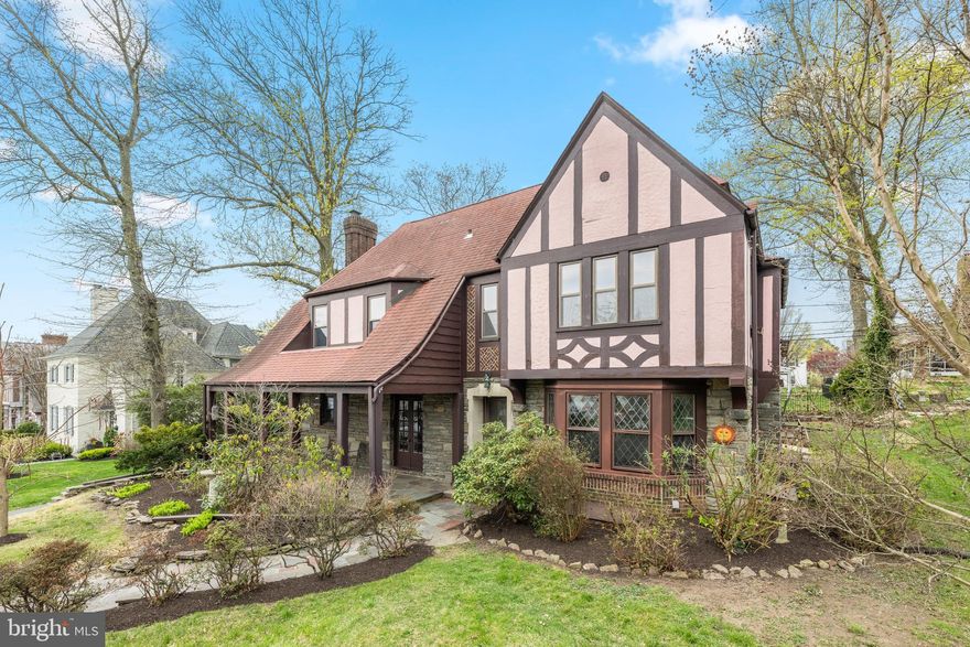 Welcome to 522 Brookfield Rd, an English Tudor home with historic character and grace, complemented by modern conveniences in the highly desirable community of Drexel Park, situated in Drexel Hill, Pennsylvania. Stroll up the flagstone walkway to an inviting front porch, perfect for relaxing with your morning beverage, greeting visitors, or socializing. Step into this three-story, five-bedroom, four-bath home through an impressive wood chevron front door with stained glass into a gracious foyer featuring an oak staircase. The entry is flanked by an oversized living room and dining room, rich with beautiful wood accents. The living room features a gas fireplace framed by two built in bookcases and double doors leading to the front porch, extending your entertaining space. French doors open to the formal dining room, with crown molding and highlighted by a delightful and original bow window. The foyer, living, and dining rooms feature wider-plank pegged solid hardwood floors. A large eat-in kitchen beautifully blends old and new, showcasing vintage built-in cabinetry on the left as you transition from the dining room. The kitchen offers additional abundant cherry cabinetry, an island with cooktop, granite countertops, double oven, stainless steel refrigerator, dishwasher, microwave, and LVP flooring. A back staircase is convenient and provides additional access to the second level. The garage is just steps away and a half bath completes the main floor. The second level includes four bedrooms. The oversized primary suite features two closets with natural light, a cedar-lined closet, and access to a private bathroom. The primary bath is highlighted by original 1920s tile and distinctive character. The second and third bedrooms share a Jack and Jill bathroom with original tile, timeless character and the doors have a mechanism to auto-turn the bathroom lights on. Down the hall is a fourth ensuite bedroom with private bath and convenient proximity to the secondary staircase, offering easy access to the kitchen below.  The third floor offers a fifth bedroom or office, a walk-in closet, a fourth bathroom, and attic access. A full basement completes the home, ready for a new owner to make it their own. In addition, this house is unique with an old milk door (in main floor hallway currently inactive), many closets have lights to turn on automatically, diamond shaped glass front window and more. Enjoy the backyard with a seating area and calming pond—an ideal space for relaxation. The outdoor setting is storybook with seasonal plantings that bloom throughout spring and summer. This home is filled with character and charm, offers ample parking, and a highly convenient location within walking distance to local schools. Nestled in the beautiful community of Drexel Park the neighborhood is known for its close-knit atmosphere, with many social activities and exceptional convenience.  Just a block away, enjoy peaceful walking trails and the historic Greenhorn Gardens—an urban farm and greenhouse open daily, offering plants, flowers, and fresh vegetables. Located within the scenic 130-acre Arlington Cemetery grounds, this beloved local destination is both beautiful and unique , also offering other activities. Another nearby farmers market can be found just down the road in Lansdowne.Enjoy easy access to everyday amenities, public transportation, and major highways, making commuting a breeze. Just a short two-block walk away, the trolley provides direct connections to shopping destinations, sports venues, and downtown Philadelphia—outstanding for both work and leisure.
