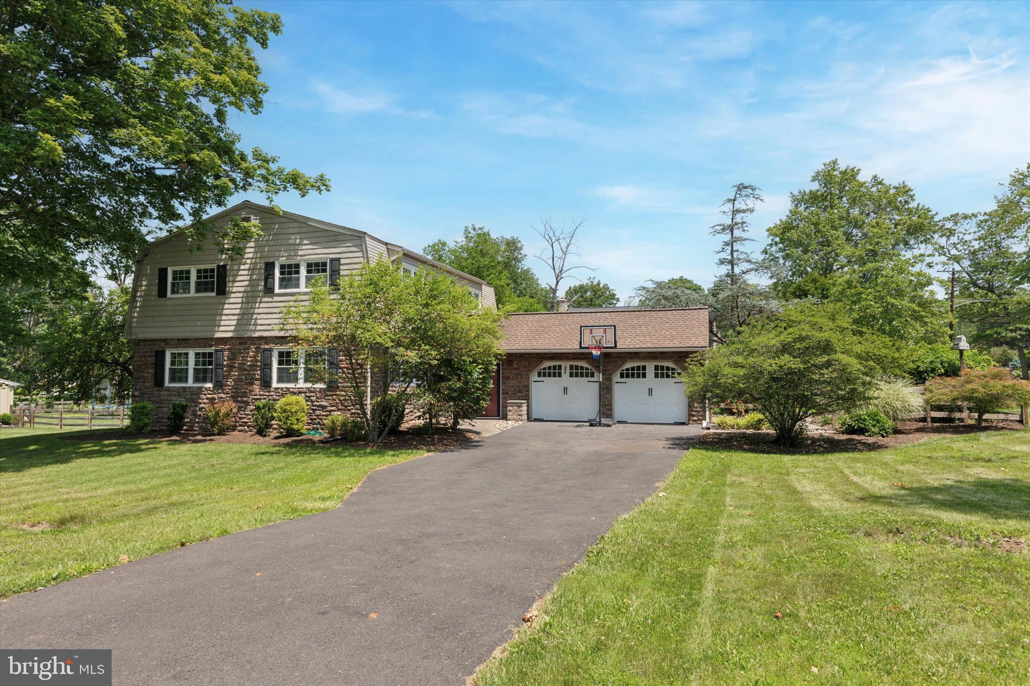 Perfectly Positioned on a Large Corner Lot in East Norriton. Don’t miss the opportunity to own this beautifully updated colonial, ideally situated on a quiet, sought-after street in East Norriton. Set on a picturesque large corner lot, the home is framed by a charming stone façade, lush manicured lawn, and vibrant gardens—offering exceptional curb appeal. This classic 5-bedroom, 2.5-bath residence features a spacious layout, an attached 2-car garage, and a fully finished basement, providing plenty of room for comfortable living. Step into the inviting foyer and make your way through a sun-filled first floor designed for both everyday living and entertaining. The expansive living room, bathed in natural light, flows seamlessly into the formal dining room—an ideal space for gatherings. The eat-in kitchen offers an abundance of solid wood cabinetry, stainless appliances, and opens into a cozy family room, complete with a wood-burning fireplace. From the family room, step into a bright and airy sunroom that opens to a stunning paver patio—perfect for outdoor entertaining. The fully fenced backyard offers ample space for play, gardening, or relaxing in privacy. A first-floor home office (or 5th bedroom), a convenient half bath, laundry room, and direct access to the oversized 2-car garage round out the main level. Upstairs, the spacious primary suite boasts a walk-in closet and a newly renovated en-suite bath featuring a beautifully tiled shower with glass doors. Three additional generously sized bedrooms and a well-appointed hall bath complete the second floor. Located just minutes from the PA Turnpike, Route 422, the Blue Route, King of Prussia and Plymouth Meeting Malls, Einstein Hospital, Norristown Farm Park, Elmwood Park Zoo, and scenic bike and hiking trails—this location truly has it all.