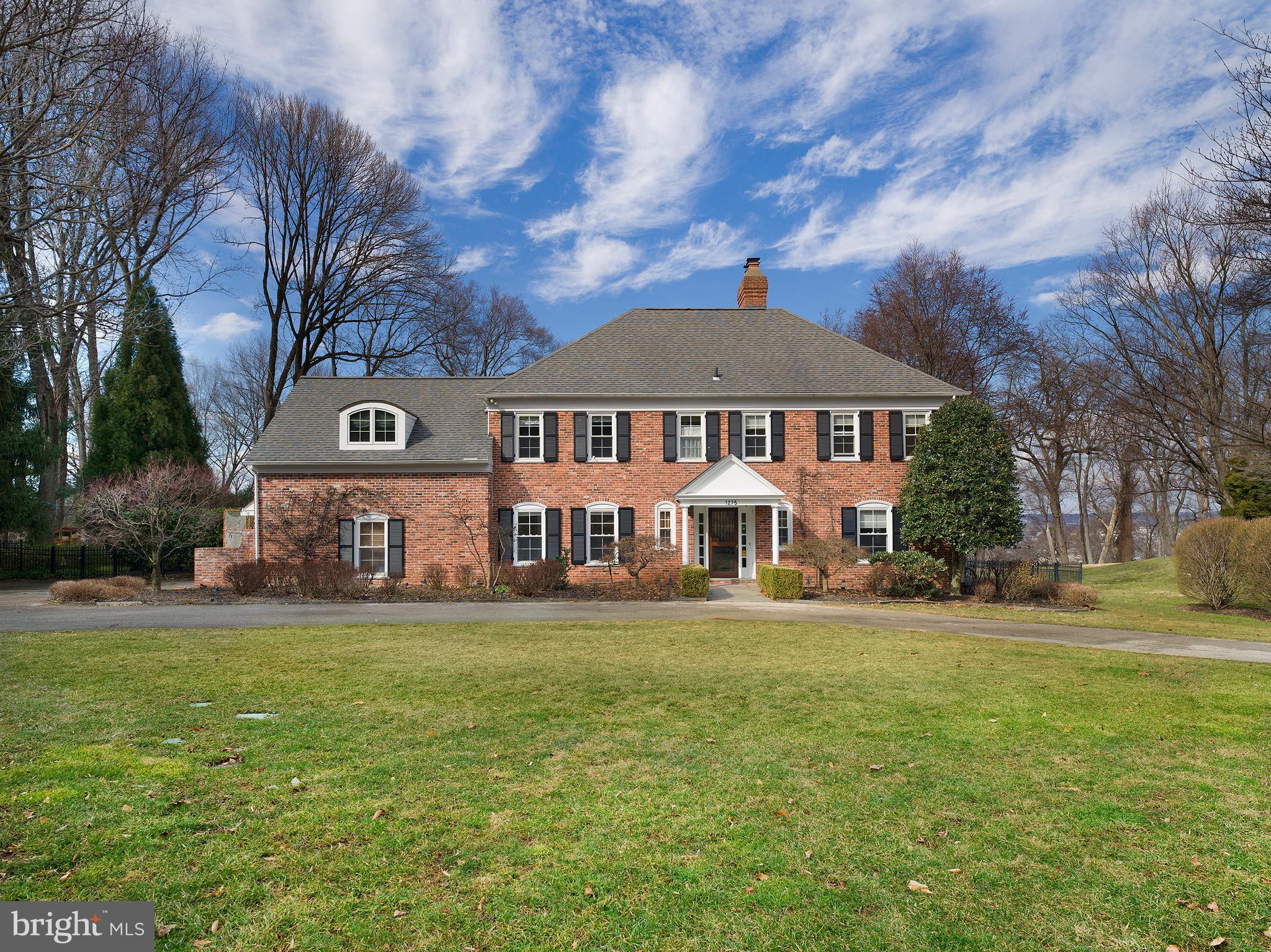 Don’t miss out on this incredible home with a brand new first floor renovation located in a quiet yet well-connected neighborhood, close to award-winning Lower Merion schools, the Philadelphia Country Club, and more. With generous living spaces, an open, bright floor plan, incredible outdoor space, tons of privacy, and new updates throughout, 1275 Club House Road is ready for you to make it your home.
A grand circular driveway, meticulous landscaping, and custom Mahogany front door welcome you into this beautiful center hall brick colonial.
The main level has everything you need for entertaining friends and family. The sellers just completed an entire first-floor renovation to make this their forever home, but a new job opportunity means the next buyer will get to enjoy the attention and quality of these meticulous renovations. On one side you have the formal living room with a gas fireplace which opens to a newly installed wet bar and spacious family room. The family room features a full wall of windows overlooking the lush private backyard. From the wet bar, French doors lead you to the newly added 3-season room with flagstone floors, radiant heaters, and large windows that frame each season’s beauty and allow you to relax all year round. Just a couple of steps away is the open kitchen that is fully equipped with modern features, like quartz countertops and brand new high-end appliances, including a Sub-zero fridge, Thermador oven/cooktop (on backorder) and a Bosch dishwasher, and classic ones, like a wood-burning fireplace. Off of the kitchen, you have a large, light-filled breakfast room to start every day right.
On the other side of this level, you’ll also find a large versatile space that can serve as anything from a formal dining room to an office with a double door entrance and access to the kitchen. Finishing out the main floor is a formal powder room near the foyer and a laundry room, with a second powder room, that leads out to the fabulous outdoor space and the attached 1.5 car garage. Hardwood, radiant heated floors bring together the main level of this magnificent home.
Upstairs you have 5 bedrooms and plenty of storage space across two floors. First, on the second floor, escape to the owner’s suite with an oversized dressing room/closet and luxurious primary bathroom with a sunken jacuzzi tub and heated floors. French doors lead from the primary bedroom to an expansive deck with views of the incredible grounds. There are three other bedrooms on this floor, two share a hall bath, and the other boasts its own private bath. On the third floor, there is another spacious bedroom, a full bath, and plenty of additional closet space.
Down in the finished lower level, you will find a dry bar, versatile bonus room, and full workshop to cultivate all your hobbies. Here you also have a Bilco door with access to the outside and tons of additional storage as well.
Outside you have even more to love with the beautifully manicured grounds, sizable pool, and abundant outdoor space. The 3-tiered backyard, with landscaped and lighted rock wall, backs up to wooded acreage for maximum peace and privacy. Add a spring-fed fish pond with waterfall and you have a tranquil oasis from the bustle of everyday life. Plus, the built-in barbecue by the pool is perfect for al-fresco dining and makes entertaining easy on those hot summer days. A whole house back-up generator and large storage shed with electrical completes this newly renovated home. You don’t want to miss this one.