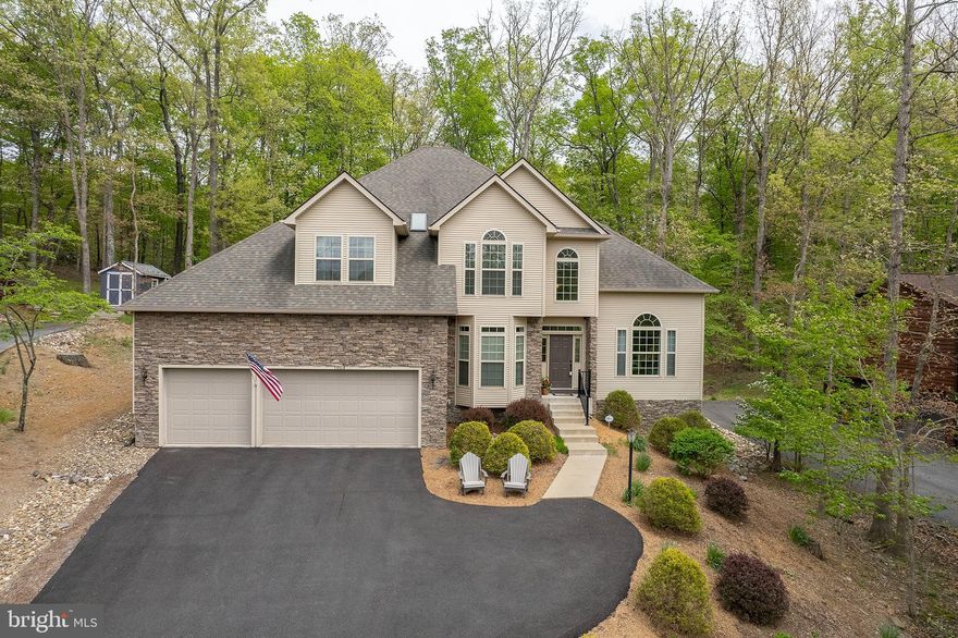 LIKE NEW AND PERFECTLY LOCATED BETWEEN LAKE VIEWS AND BACKS UP TO ACRES OF GREEN SPACE! This better than new CUSTOM-BUILT home comes with every upgrade and is impeccably kept inside and out! HUGE 3 CAR GARAGE offers a separate basement access leading to a workshop, recreation room, and tons of storage! Walking into the 2-story foyer, you’ll find chestnut hardwood flooring, crown molding, custom staircase, an office/den and living/dining room combo. The gourmet kitchen is perfect for entertaining with upgraded appliances, granite counters, kitchen breakfast bar, coffee station, butler's pantry with utility sink AND another pantry! This one-owner’s home is designed with every efficient convenience including upper floor laundry, large bedroom sizes, tray ceiling in primary bedroom, huge ensuite bath including separate walk-in shower and soaking tub. Gorgeous family room off kitchen boasts a stone fireplace, built-in cabinetry and is steps away from a relaxing screened-in porch and fenced-in rear yard. Property backs to acres of green space/common area that offers privacy galore! Permanently installed generator conveys. This is a MUST-SEE property with gorgeous hardscaping and a super short stroll to clubhouse hub and fitness room, volleyball/pickleball/tennis/basketball courts, sandy beach, playground, and fishing pier. Bring your speed/pontoon boat that will graciously fit in the extra-long garage space! Green space behind home offers disc golf, walking trails, dog parks and another playground. This 24/7 gated lake community is your dream come true … just 20 minutes from Winchester and hospital! Xfinity high speed internet provides work from home capability.