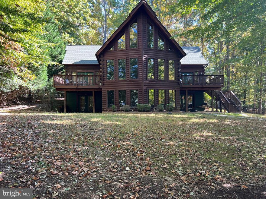 Fabulous  3750 sqft 5-bed, 3-bath log home located in the gated Tyler Point community on the Public Side of Lake Anna. The main level has 3 bedrooms, a kitchen with a sit-up bar, a dining room with seating for 10, and a family room with a wood-burning fireplace and floor-to-ceiling windows overlooking the lake. On either side, decks provide outdoor seating and entertainment space. Upstairs, the primary bedroom and full bath adjoin a sitting area that provides a private space for reading or relaxing. The 5th bedroom is downstairs along with 2 family/great rooms and a bonus room that is currently used as a bunk room (not to code). Outside patios offer more entertaining space. The shoreline with  400' of sea-walled waterfront has a sand "beach" area as well as a boathouse with 2 slips, a storage area, and a large sundeck. Long views from the boathouse and easy access to the largest part of the lake. Tyler Point is close to El Patron restaurant and only a short drive from the lake's other amenities, breweries, wineries, and restaurants. ALL contents of the home can be conveyed with an acceptable offer.