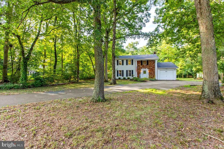 115 Woodmoor Rd  is ready  for its new owners to claim it, and make it their own! Sitting on a large nearly 3/4 of an acre lot, this charming colonial style home is sure to check off all your boxes.  The main floor has a spacious living room which connects to a bonus room; currently shown as a dedicated dining room but can be an office, sitting room, play room- so many options to fit your specific needs!  The kitchen has ample counter space, room for a sitting area and table space. The attached garage leads directly into the mud room/laundry room. Upstairs you will find FOUR nice sized bedrooms and two full bathrooms; which includes the Primary Bedroom with Ensuite.  Outside you will enjoy running around and relaxing in the backyard, surrounded by mature trees and backs to wooded area, adding extra privacy.  The community of Matapeake Estates is peaceful, surrounded by woods and the Chesapeake Bay! There is a community beach for residents to use- catch a beautiful sunset, have a picnic or swim in the Chesapeake Bay.  Have a boat?  There are two public county boat launches close by;  Matapeake which leads directly into the Chesapeake Bay and Shipping Creek which will take you right over to the Eastern Bay. If you enjoy going for walks, you'll love the Southern Kent Island Trail which begins just outside the community's entrance. This home is less than 5 miles from the Bay Bridge, making it an easy commute to the Western Shore. Matapeake Elementary & Middle School and Kent Island High School. Get ready to live and enjoy the Island life. 
The community will be switching to public sewer in Phase 4 of the Southern KI Sewer Project.