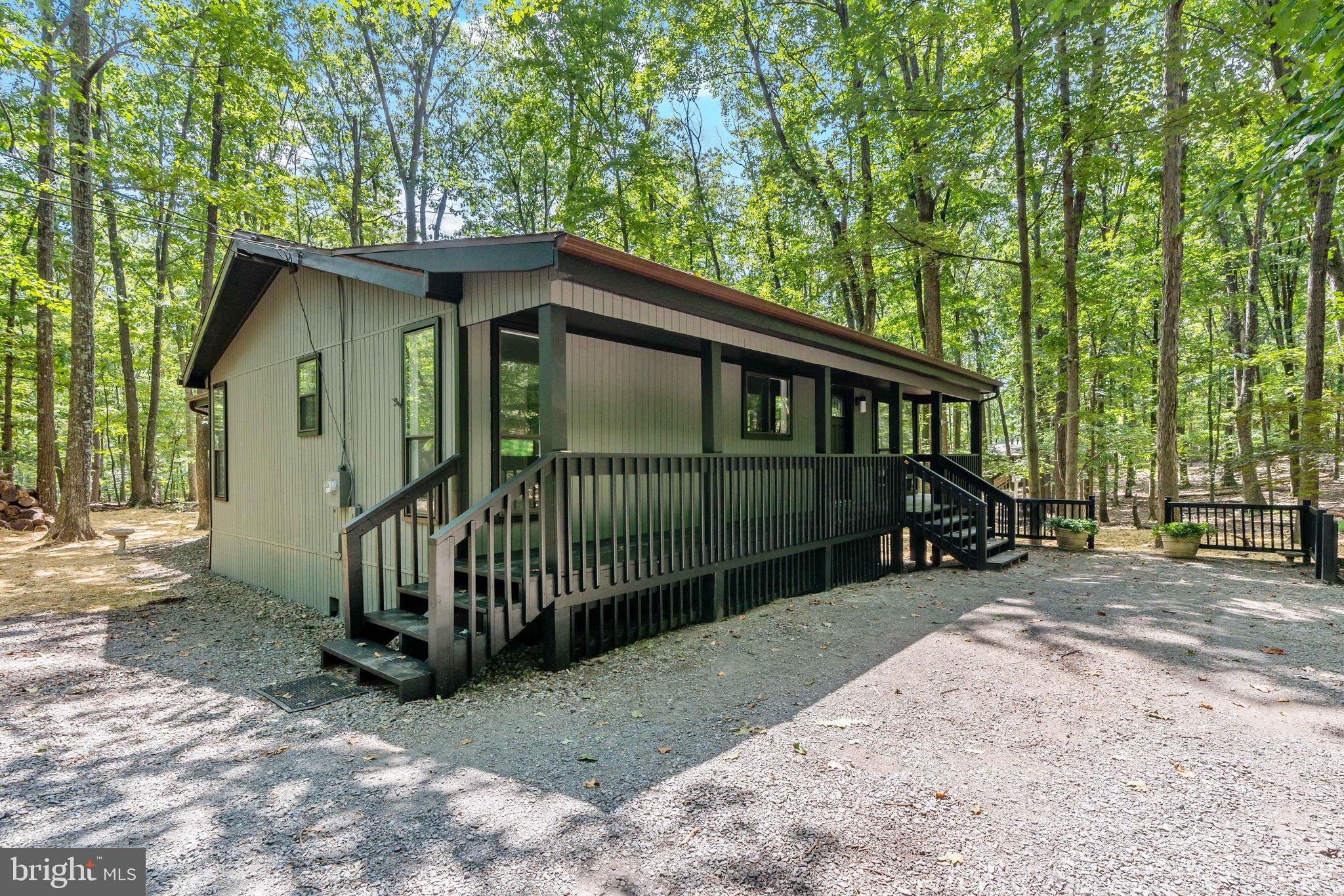 Cozy Cabin in The Woods Resort
Tucked away on a private wooded lot in the desirable Woods Resort, this charming 3-bedroom cabin blends rustic comfort with modern updates. The spacious primary suite features its own private deck, perfect for morning coffee or stargazing at night.
Enjoy the warmth of the fireplace in the newly updated kitchen and living area, complete with luxury vinyl plank flooring, granite countertops, stainless steel appliances, and upgraded lighting. Bedrooms feature brand new carpet, and the bath boasts stylish tile upgrades and a modern vanity.
Relax and unwind in the large screened-in porch with beautiful lighting, or take in the peaceful surroundings from the huge front porch. A generous driveway and an outbuilding offer plenty of storage for all your gear.
Experience country living at its best—quiet, comfortable, and close to all the amenities of The Woods Resort.emarks to come