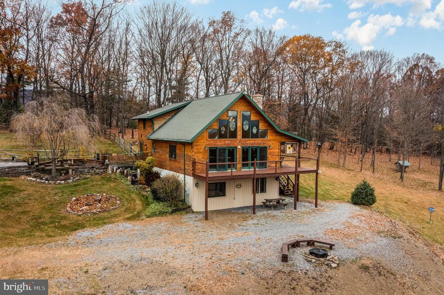 Look no further! This hard-to-find perfectly positioned 4 bedroom 3 full bath custom built log cabin with an oversized 4 car garage shop that is off a long meandering driveway on 60.846 breath taking acres with mountainous scenic views can be all yours. This Juniata County beauty has it all from its current 2 tax parcel set up providing easy potential for further subdividing  to all of the wonderful upgrades and features throughout the unique open floor plan home.  As you enter the home you are warmly greeted with the dramatic 2-story sun filled Great Room that boasts a stone wood burning fireplace that has an oversized slate hearth, 6 sun filled 2 story window panels facing the front of the home, 2 doors with a total of 6 panels that lead out to the wrap around deck,  dramatic timber roof trusses, wood pine ceilings throughout with track lighting along with two ceiling fans, built-in television entertainment cabinet stand,  pine walls, and custom pull down blinds.  The Kitchen with all its modern-day amenities and exquisite WOW factor is outfitted with rarely seen custom red oak soft touch cabinetry throughout, an island area with 5 burner cook-top stove,  built-in Whirlpool double oven, dishwasher, double sink and perfectly placed window  with views of the detached garage/shop area.  Off the Kitchen you will delight in the Main Floor Bedroom with a built-in desk, pine wood ceiling and walls, large double closet as well as a tucked away side closet behind the door, custom blinds on both windows and a ceiling fan. Rounding out the main floor area is the Hall Bath with wood pine walls and flooring, corian sink, linen closet, tub/shower combination and doors that conveniently lead to access from the hall or the bedroom along with the Laundry area with a sink, closet and fire rated door that has a screen storm doggie door that leads outside.  A quieter mood prevails upstairs within the private spaces of the second-floor level.  The Primary Suite is an airy sanctuary providing a peaceful place to unwind and bask in all the wonderful  views.  Situated for privacy and designed for comfort, this room features an open loft area, built-in 9 drawer dresser along with a pine bed, ceiling fan and custom window shades.  The primary bath has it all with a cathedral vaulted ceiling and make-up area.  The at grade lower level area comes equipped with 9 foot high ceilings throughout, a Hall Bathroom with a stand up shower along with corian counter tops, there is also an oversized Bunk Bedroom that easily fits 4 beds, a game room which originally was set-up to be the garage, and lastly the additional 4th bedroom with a kitchen area that has a double sink as well as cabinets along with the Utility Room.  Additional upgrades and features include: the detached garage shop has a wood stove, animal wash area along with a bathroom, a 24'x14' storage shed is included, seller has pre-purchased many parts he keeps in reserve for the heating system and has a future well pump he is leaving with the new homeowner, there is 5 zone heating along with central air-conditioner, there is an electrical outlet that can be used for a future  generator, water softer, two supplemental space heaters in place in the kitchen as well as the primary bathroom, gutter guards have been installed, recessed lights under the wrap around porch deck and great working television and internet service due to a Direct TV hook up that has wonderful reception.  You will be amazed by all of the wildlife that will come to visit you such as turkeys, porcupine, deer, fox, opossum, and bears.  You can't go wrong with the homes location being only 1 hour to the Penn State campus,  1 hour and 20 minutes to Raystown Lake, and just 1 hour 15 minutes to Harrisburg and is only a hop, skip and a jump to State Game Lands 88 and 215 by way of your ATV .  Come make this mint condition log cabin your new home today!