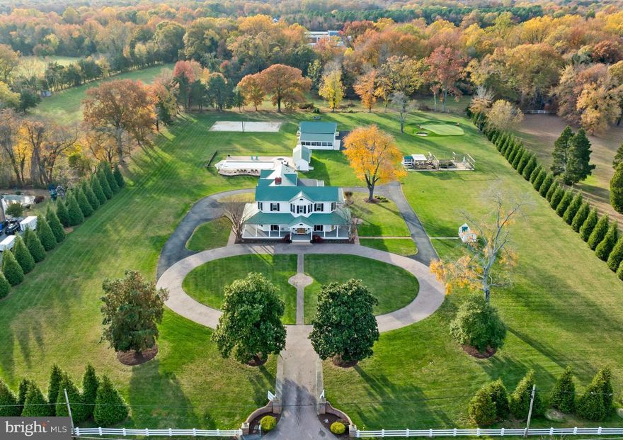 Step into timeless elegance with this one-of-a-kind historic, almost 5000 sq ft estate, fully renovated in 2022 and thoughtfully modernized while preserving every ounce of its original charm! Perfectly situated on nearly five flat, usable acres, this property combines luxury, character, and resort-style amenities. The outdoor grounds are designed for both relaxation and recreation, featuring a fenced in-ground pool (all equipment replaced in 2019), a pool house complete with an additional full bath and kitchenette, volleyball court, par-3 golf hole, chicken coop, and gardening area. Outside also includes a detached shed with a carport and a two-level storage barn (which could easily be converted into a detached garage as well) with a finished loft and pellet fireplace, offering endless possibilities… ideal for a home office, home schooling, a studio, or a guest suite. Enjoy evenings on the wraparound porch (redone just 1 year ago) or gather around the outdoor brick fireplace for year-round entertaining… you can truly have it all here! Inside, the grand foyer sets the tone with a sweeping staircase and rich heart of pine hardwood flooring that flows throughout. The office off the foyer features tasteful built-ins, while the spacious formal dining room centers around a striking gas fireplace. The living room showcases a historic bar, a free-standing gas fireplace, and doors leading to the outdoor living area. The kitchen is truly the showpiece of the home — a breathtaking chef’s space with Italian Officine Gullo sinks, a 60” Italian double oven with heritage knobs, Sub-Zero paneled refrigerator, drawer dishwasher, dual reverse osmosis faucets, porcelain counters, coffered ceilings, a HUGE island with an additional sink, and tons of cabinetry… all overlooking the sweeping views of the backyard and pool area. An additional stunning family room with a wet bar and access to the wraparound porch, a half bath, and access to a convenient basement storage area complete the main level. Upstairs, the primary suite offers abundant natural light, two walk-in closets, and a spa-inspired bath with dual vanities, a soaking tub, and walk-in shower. Three additional bedrooms share a beautifully updated full bath, while a guest suite with an additional full bath provides perfect accommodations for visitors (5 bedrooms total upstairs).  Upstairs also includes a well-designed laundry room and walk-up attic with tons of storage space! Impeccably maintained and unlike anything else on the market... this extraordinary home offers the rare combination of historic character, high-end craftsmanship, and modern livability. Welcome to your next chapter!