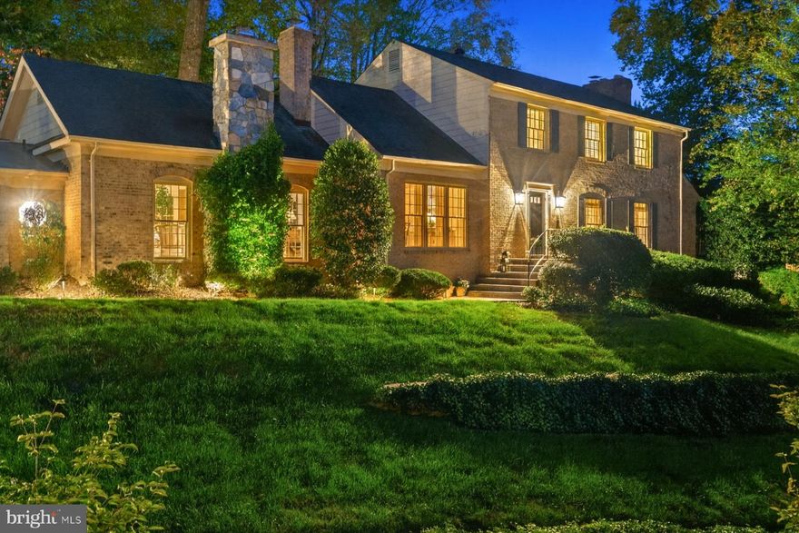 For those looking to Right-Size in style, this colonial offers an inviting, manageable layout paired with gracious entertaining spaces. Two generous gathering rooms and a fireplace-lit dining room create the perfect backdrop for hosting or unwinding close to everything DC has to offer.

Where location is the ultimate luxury, this home sits in The Dogwoods—one of McLean’s most coveted neighborhoods—just one stoplight from the DC line and offering unrivaled access to downtown McLean, Tysons, Bethesda, the GW Parkway, Reagan National Airport, and more.

Perched proudly on a terraced hill, the residence stands apart with the presence and grace of a distinguished estate. While many homes in the neighborhood were built in the same era, this one feels like the original—its elevated setting, expanded layout, and architectural character make it truly incomparable.

The main level is both expansive and elegant, beginning with a grand living room anchored by a stone fireplace flanked by built-in bookcases. The formal dining room makes its own statement with a second fireplace and built-in shelving—ideal for unforgettable gatherings. A stunning family room with cathedral ceilings and a third fireplace offers warmth, volume, and a beautiful connection to the serene outdoor spaces. Every main-level room—including the living room, dining room and family room—opens through French doors to the rear courtyard, creating an effortless indoor–outdoor flow. Additional main-level highlights include a charming breakfast room, dedicated laundry room, two powder rooms, and garage access.

The kitchen captures relaxing views of the backyard and blends function with charm, complemented by its cozy adjoining breakfast room. Upstairs are four spacious bedrooms. The primary suite features walls of windows, a sitting area, and generous closet space. The primary bath offers an oversized tub, walk-in shower, and incredible potential for a fresh, modern redesign. Hardwood floors lie beneath the carpeting on the upper level.

The partially finished lower level combines character with versatility, offering rich knotty-wood paneling, custom built-in shelving with a dedicated work station, and a flexible bonus room perfect for a private gym, studio, or hobby space. A large utility/storage room includes a Bilco door for discreet exterior access—ideal for storage or contractor entry.

Outside, the private flagstone courtyard is a true sanctuary, bordered by lush landscaping and centered around a gracefully shaped, heated swimming pool. With the charm of a Cotswold retreat, this outdoor haven feels like a hidden treasure—perfect for quiet moments or lively entertaining.

A rare opportunity for those who value both sophistication and convenience. A location—and a home—where nothing else compares.