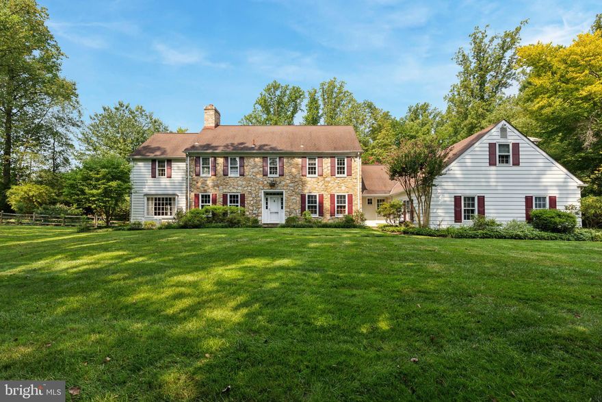 Welcome to this enchanting stone and clapboard style colonial residence, gracefully situated on over three lush acres. This home features an open first floor layout with many options for entertaining and a comfortable lifestyle.  
As you enter, you'll be greeted by a light-filled entrance hall with a circular staircase, flanked by a cozy Den with a fireplace and beamed ceiling and a stately Library/Office with a wall of bookshelves. An all-glass breezeway with a flagstone floor seamlessly connects the indoor and outdoor spaces, as well as leads to a step-down living room, adorned with a second fireplace and French doors to the outside patio and pool area.  The formal dining room and country kitchen, which flows into the family room, offer ample space for entertaining and everyday living. The family room is bathed in natural light with its all-glass view of the expansive yard. It boasts a fireplace, vaulted ceiling, a wet bar and random width floors.  Convenient first floor laundry room connects from the kitchen.  Beyond it is a well thought out full bathroom for guests and family members to use while enjoying the inviting in-ground pool and private grounds. 
On the second floor, you'll find four spacious bedrooms, one, ensuite with a power room and an additional hall bathroom.  The primary suite includes a bay of closets, a primary bathroom with a separate tub and shower, and a charming small balcony overlooking the yard. An additional bedroom and bath, accessible from the kitchen area, provide versatile accommodation options.
Completing this exceptional property is a two-car attached garage, ensuring convenience and functionality. Conveniently located near the charming town of Ambler which offers a train line to the City,  as well as excellent restaurants and a movie theater.  Walking distance to the Wissahickon Creek and local schools.  Only minutes from the PA Turnpike.  Experience the perfect blend of elegance and comfort in this stunning home in a serene private setting.