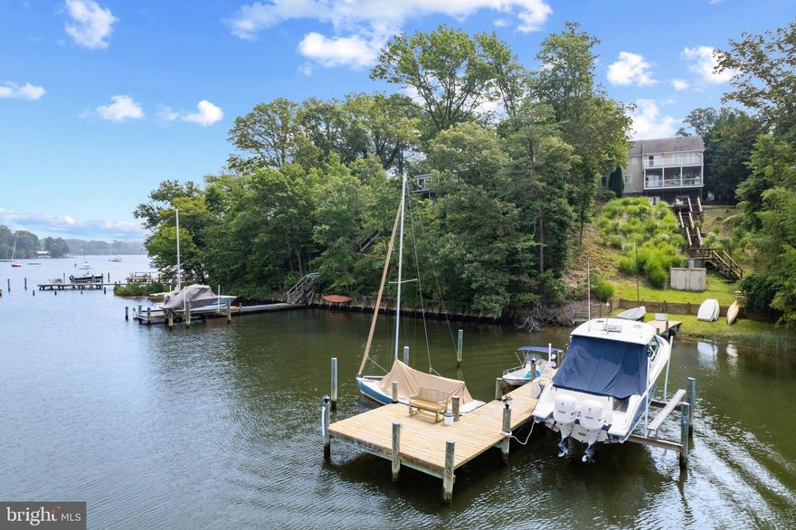 The perfect waterfront getaway or year round home! This beautifully updated waterfront home overlooking Valentine Creek off the Severn River has it all. The light and bright upgrades to this fabulous home greet you as you enter the 2 story foyer with grand staircase.  Become immediately captivated by the stunning views through the house and out to the expansive covered rear deck constructed with low maintenance finishes so you can spend all your time enjoying the waterfront lifestyle.  Recently refinished light wood floors throughout, new carpet, shiplap accent walls, white kitchen cabinets, lighting upgrades, and reconfigured lower level are just a few of the recently completed projects throughout the home. The classic colonial layout provides formal dining and living spaces at the front of the home and flows seamlessly to the open floor plan overlooking the waterfront from the Family Room with cozy fireplace and gourmet Kitchen with island and eat-in area.  The main level office is conveniently located adjacent to the full bath, rear entrance, mudroom and garage.  The unique circular driveway allows you to drive through the garage for easy maneuvering and plenty of parking for family and guests.  4 bedrooms, 2 with ensuite baths, await you on the upper level, including the luxurious Primary bedroom with seating area, vaulted ceiling, private balcony for enjoying nightly sunsets and beautifully appointed bath with separate tub and shower, double vanity and walk in closet. An additional 550+ sq ft of finished space above the garage is perfect for utilizing in whatever manner suits your needs.  Guests/in-laws/au pair can enjoy their own private accommodations in the lower level of the home featuring high ceilings, full kitchen, living room, bedroom, full bath and multiple glass sliders to enjoy the endless water views and to access the covered patio which leads to the water's edge.  Enjoy the sandy beach and private pier with electric, water 16 x 12 seating area, 12,500lb boat lift and deep water (7ft MLW).  A dream pier and location for the boating enthusiast with quick access out Valentine Creek into the Severn River and beyond to the Annapolis Harbor and the Chesapeake Bay.  Conveniently located off General's Highway which provides quick access to downtown Annapolis, BWI, DC and 97. Welcome Home!