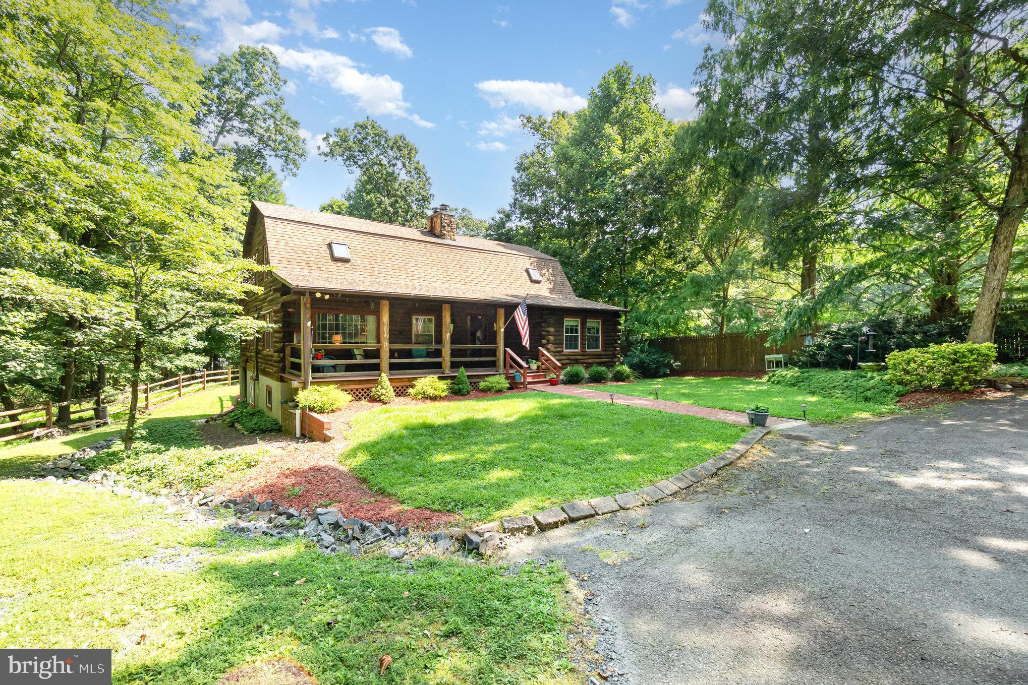 Escape to tranquility with this charming 3-bedroom, 2-full-bath log cabin nestled on over an acre of lush land. Boasting warm, inviting wood accents and and a finished basement, this home combines rustic charm with modern comfort. Recent upgrades include a new garage roof in 2024, new HVAC system in 2023, new well pump in 2022, new windows in 2023, new Trex deck in 2020, and a new hot water heater in 2020. The spacious outdoor area is perfect for gardening, outdoor entertaining, or relaxing in nature. A detached two-car garage provides ample storage and convenience. Whether seeking a peaceful retreat or a cozy family home, this log cabin offers the perfect harmony of comfort and nature.