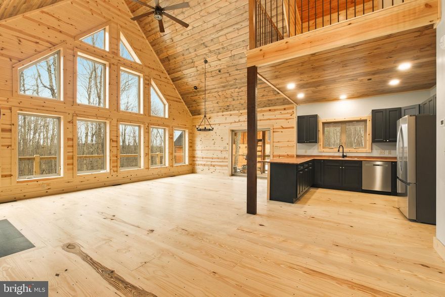 Brand New Log Style Chalet at Deep Creek Lake! Completed in 2026, this newly constructed mountain retreat pairs refined design with a focus on efficiency and long-term performance. The open-concept layout is defined by soaring vaulted ceilings, expansive windows, and curated natural wood finishes that bring warmth and scale to the space. The stylish tile fireplace anchors the main living area, creating a striking focal point for both everyday living and entertaining. The kitchen is thoughtfully appointed with stainless steel appliances, custom cabinetry, and an oversized island designed for gathering. A loft overlooking the great room offers additional flexibility for a secondary living space, office, or guest accommodations. Each bedroom and bath is finished with a consistent attention to detail, delivering a cohesive and elevated feel throughout.
Built with energy-conscious features and quality materials, the home is designed to maximize efficiency while maintaining comfort in every season. Outdoor living is equally intentional, with an expansive deck set against a private wooded backdrop—offering a quiet extension of the interior living space.
Ideally located just minutes from Deep Creek Lake, Wisp Resort, and area amenities, this property presents a compelling opportunity for those seeking a primary residence, second home, or high-end investment with lasting value.