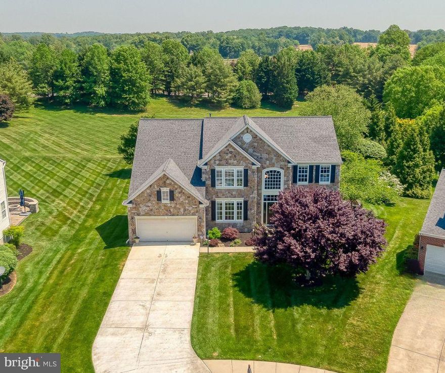 This stunning 3-level stone colonial in Stone Ridge is situated on a quiet cul-de-sac. The home offers 5 spacious bedrooms, 4.5 baths, and beautifully designed living spaces, The fully renovated gourmet kitchen (2021) features quartzite countertops, marble backsplash, custom cabinetry, stainless steel appliances and opens seamlessly to the sunroom and dramatic two-story family room. The luxurious owner’s suite includes a private sitting room and spa-like bath with a soaking tub and separate shower. The fully finished walkout lower level is ideal for an in-law or au pair suite, complete with a large bedroom, full bath, kitchenette, media room, expansive rec room, and custom office space. Step outside to a professionally landscaped yard featuring a maintenance-free deck,  paver patio with built-in grill, and stone firepit -perfect for outdoor entertaining. The lot backs to common space. Recent updates include: Roof (2024); 
Kitchen Renovation (2021); Hardwood Floors (2021); Water Heater (2021); Front Door; and Custom Office Build-Out.
