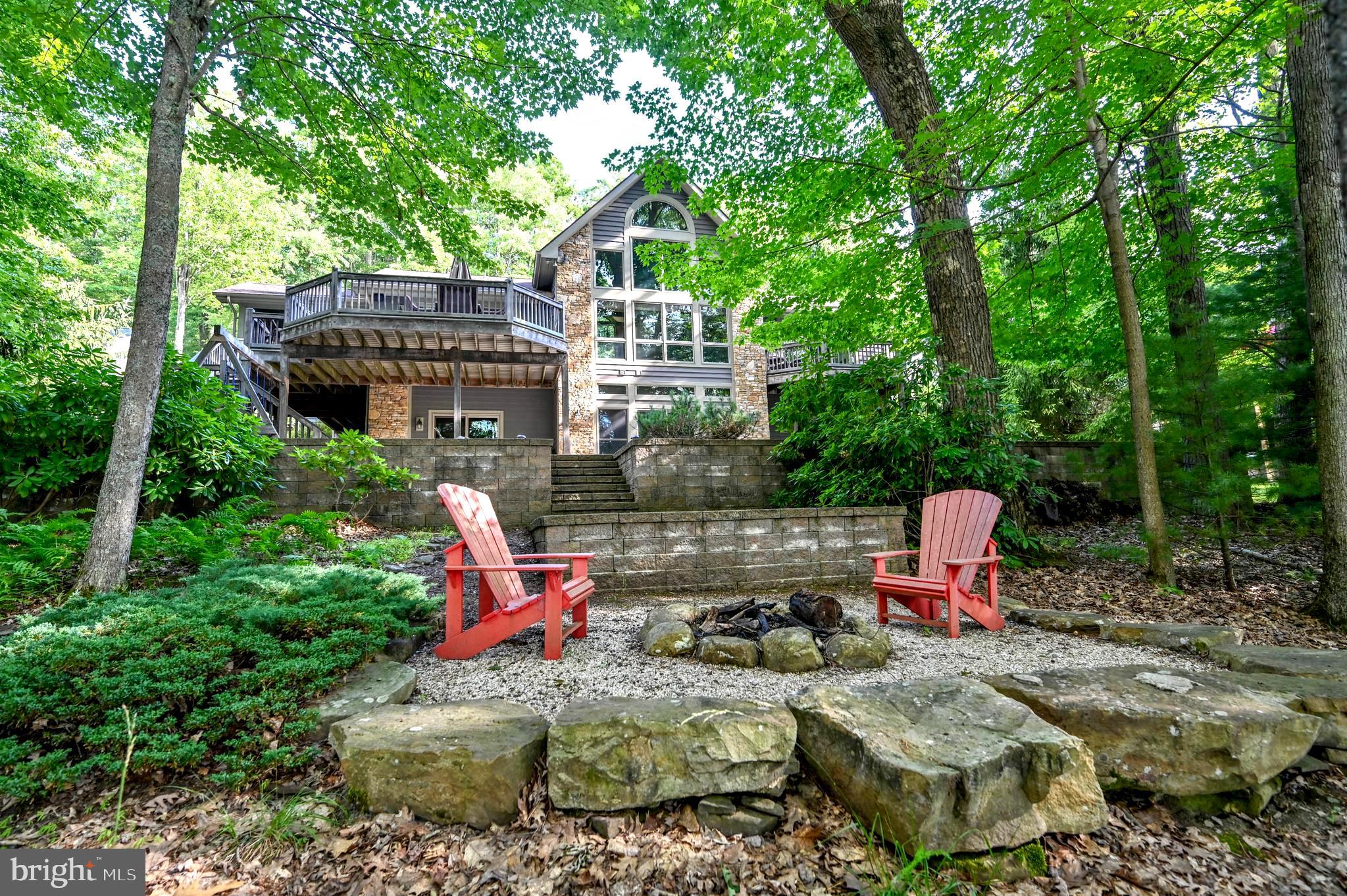 Discover the ultimate retreat with this stunning lakefront home perfectly situated on the shores of Deep Creek Lake! Boasting six spacious bedrooms and four and a half baths. Enjoy the grandeur of high cathedral ceilings in the main living areas creating an open and airy ambiance. The floor to ceiling windows offer panoramic views, with a stone fireplace that completes the picture. Beautiful hardwood floors throughout the living areas. Room for all in the spacious dining area that steps out to a large outside deck. Grab a book and enjoy the outside screened in porch in rain or shine. The amazing kitchen has a large eat at bar for those backseat chefs, tons of cabinet space, granite countertops, desk area and a large pantry closet. The laundry room is a dream between the kitchen and garage. The bright and spacious main level primary bedroom has lake views, a private balcony, and a large walk in closet. The en-suite bathroom has a jetted soaking tub, a large glass, tiled shower, and a double sink vanity. The lower level is a dream with high ceilings and room for all your family and friends for movie nights. There is also has built in book shelves, stone fireplace and a wet bar! There is a second spacious, lakeside primary bedroom stepping out to the deck with a private bath. Across the hall there is the third bedroom and a bath that is also used for the family room. The large fourth bedroom is lakefront and shares a bath with bedroom number five. The sixth bedroom/bunkroom is over the 2 car garage. Ideal level lakefront features a Type A private dock, perfect for swimming and fishing or simply basking in the sun. There is a firepit area for stories and smores, and a swing set for the young at heart. This exceptional home blends sophistication with natural beauty, offering the ultimate lakefront lifestyle. It also offers unparalleled privacy with a no short term rental policy. Don't miss the chance to make this stunning property your own! Call today to schedule your private tour!