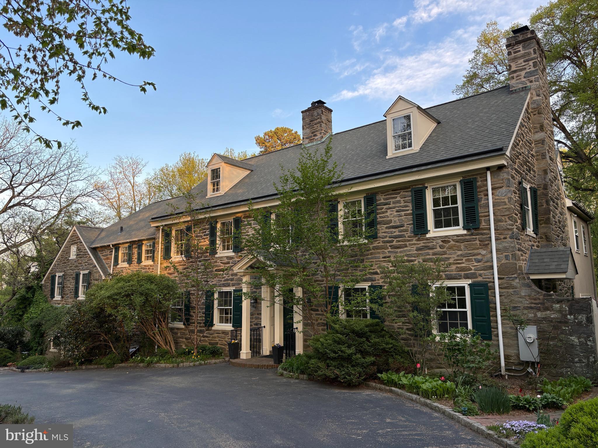 Don’t miss this classic stone colonial set on a beautifully landscaped 1.1 acre lot in the heart of northside Bryn Mawr! This timeless home is set back from the road behind stately stone pillars and a circular driveway, offering a warm, inviting presence. With 6–7 bedrooms, 6 full baths, and a powder room, there’s plenty of space for family and guests alike.
Inside, you'll find a functional layout that blends traditional charm with modern comfort. The open Kitchen flows seamlessly into the Family Room, creating the perfect area for casual, everyday living and entertaining. Gourmet appliances include a Wolf 6-burner dual-fuel gas range with exhaust hood, SubZero frig, and a warming drawer. Two sink areas provide great space for meal prep and clean-up. Just off the kitchen, you’ll find an expansive Mudroom that’s as stylish as it is practical, complete with a large Laundry Room and a full Bath that’s perfect for those summer pool days. This area also has abundant cabinet and counter space, ideal for summer entertaining at the pool. A tucked-away built-in desk area makes keeping organized a breeze. The Dining Room features built-in corner cabinets and the over-sized Living Room offers great space for formal entertaining. A soaring home Office is located behind the cozy fireside Den and provides a quiet retreat for work or study. The Sunroom, which is behind the Living Room, offers a serene spot to relax and enjoy views of the private rear yard.
Upstairs, the Primary Bedroom suite features a fireplace, multiple closets, and a vaulted, sunny Bath with skylights, a jetted tub, separate shower, double vanities, and a private water closet. Nearby, 3 more Hall Bedrooms share 2 more full Baths. Off the back staircase are 2 more Bedrooms and another Hall Bath. The 3rd floor features a Bedroom, Bonus Room, and a full Bath. The rear bedroom area or 3rd floor could also work well for an in-law or au pair suite.
Outside, the beautifully landscaped yard is a true retreat, featuring a sparkling pool, a spacious patio for dining and lounging, specimen plantings, and ample lawn for recreation.
The newer, stone, oversized 2-car detached garage includes an unfinished bonus room above — the perfect opportunity to create a home gym or studio. The partially finished basement has a wine cellar, recreation room with stone fireplace, and a wall of storage cabinets.
Located just minutes from the train, top-rated schools, shops, and restaurants, 331 Fishers Road offers classic Main Line living with space, style, and a setting that’s hard to beat.