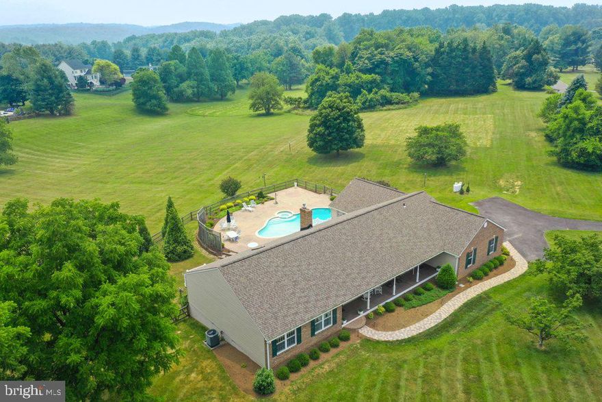 Wonderful 5 bedroom, 3.5 bath rancher in Clarksville set on a GORGEOUS three-acre lot with scenic views from every window.   This is one level living at its BEST!  You'll love the in-ground pool/spa with hot tub and hardscape surround.  The seller has maintained and upgraded this home throughout with spending over $150,000 on upgrades to the exterior and the interior!  It must be seen to be fully appreciated with features that include:  Red Oak hardwood floors on the main level, open layout with updated kitchen that is complete with stainless steel appliances, large island with granite countertops that includes a built-in microwave, wall oven, cooktop with downdraft, pendant lighting, all wood cabnetry, large butler's pantry with wine fridge, and prep sink, slider out to the most ideal (and brand new) front porch for relaxing and enjoying the view, or step down to the family room with its gas stove, barn beamed mantel, bricked chimney to the ceiling and ceiling fan.  There is also a 9-foot slider with built-in  blinds that leads to the maintenance free deck, great for entertaining as you admire the beautiful 3 acres lot.  On the other side of the brick chimney is the step down generously sized living room!  Next you'll find the separate formal dining room with plantation shutters, plus crown and chair molding.  Down the hall are 3 bedrooms, all with tons of natural light, and all with walk-in closets.  The primary bedroom has a ceiling fan, walk-in closet, ceiling fan, en-suite bathroom with sklight above, quartz topped vanity, jetted tub and ceramic tiled floor.  The primary bedroom also has a slider out to your private maintenance free deck with steps out to your own in-ground pool/spa (heated too)!  The main level also has the laundry room and half bath, but that's not all!  There is a totally separate in-law/au-pair suite that consists of two bedrooms, or use one as a bedroom and one as a 2nd living room, with a door that separates it from the rest of the house, it has the 3rd full bath and separate thermostat as well (zoned).   The lower level is at walkout level and has a cedar closet, houses the central vacuum, includes a workshop and even has a full cedar closet as well.  Windows were all replace in 2022, Roof 2018, Gutters and Siding 2022, HVACs 2022/2015, Well pump 2021, Front Porch March 2022, new paver walkway March 2023, Septic updated 2022, pool pump 5/2023, and next to the 2-car garage is the hard-wired electric plug-in for your electric vehicle!  All of this and you'll be in the RIVER HILL school district too!  You really just need to move right in and be close to shopping, resturants, route 32, 108, 97, and so much more!  Check out the virtual tour and drone photography to learn more!