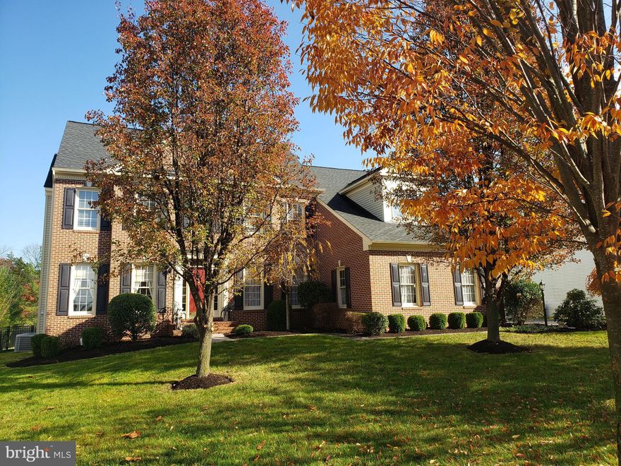 The lovely home is sited on a hard to find, spacious half-acre lot, with brick and siding  Meticulously landscaped front yard   Main level is a haven of modern living. The gourmet kitchen, light & bright with large windows, features high-end stainless steel appliances, sleek granite countertops, a culinary enthusiast's dream.    Expansive island -- perfect for gathering while entertaining!  Large dining room perfect for holidays & more!  Family room features gas fireplace w/mantel.  Walk out from family room to incredible covered porch to enjoy a relaxing oasis.

Main level primary suite is a luxurious retreat, 2 walk-in closets providing an abundance of storage.  Enjoy the spa-like primary bath with separate shower & tub plus dual vanities.  

Upper level includes 3 generous sized bedrooms and 3 full baths. Second bedroom can be used as an upper level primary suite.  One bedroom includes a rock-climbing wall!  Large laundry room conveniently located on upper level

Lower level features a spacious rec room with a gas fireplace with great space for casual entertainment.  A full bath and den offer versatility, while a bright workshop area caters to the creative spirit within.