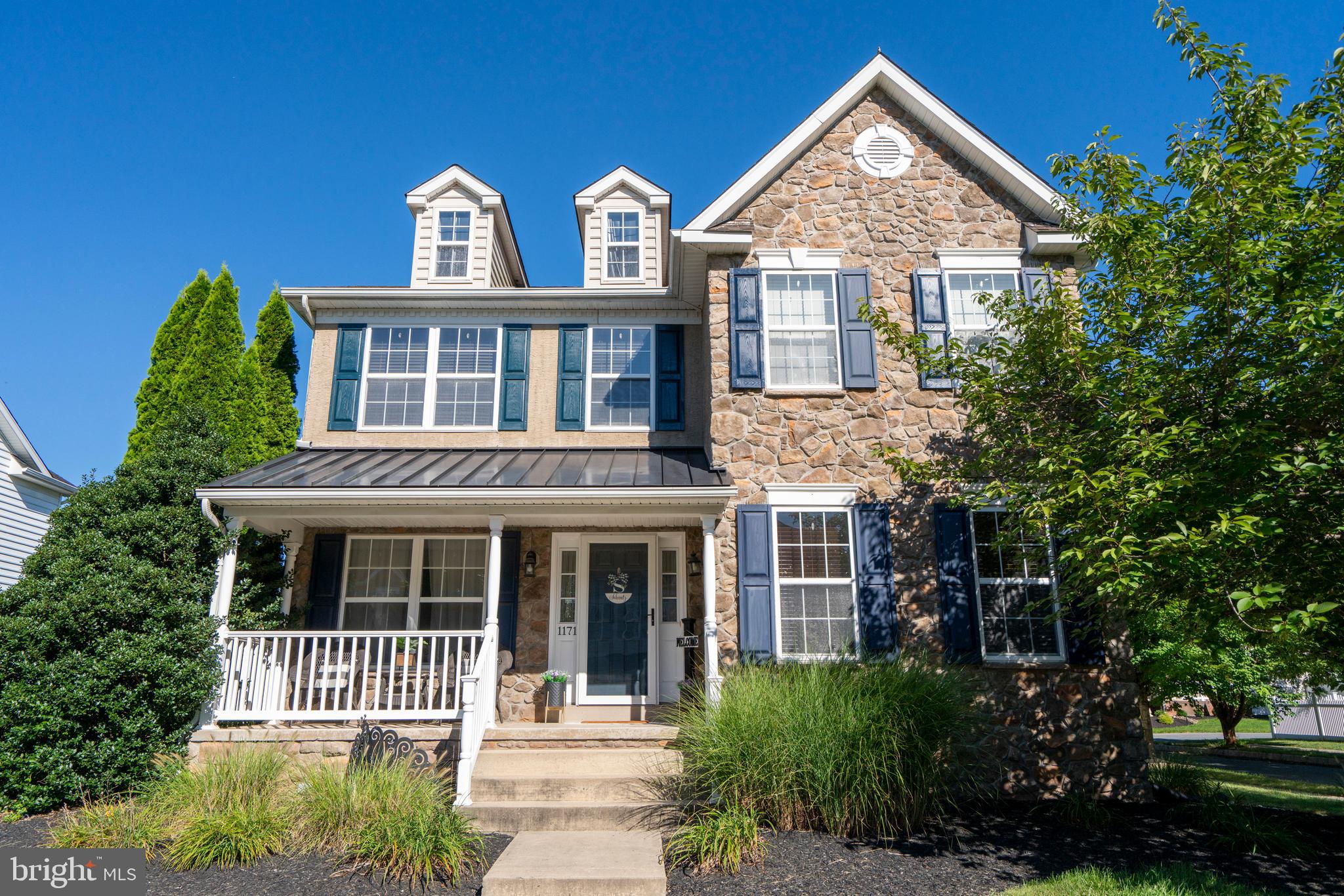Welcome to this beautifully maintained 4-bedroom, 2.5-bathroom home located in the desirable THP community of Pennsburg. Built in 2008 and lovingly cared for by its original owners, this property blends modern upgrades with community living at its best. A charming front porch, partial stone façade, and mature landscaping create a warm welcome. Inside, a wide center hallway leads to a versatile office or study with vinyl flooring and open shelving on one side, and a formal dining room with an elegant centerpiece light on the other. An updated powder room is also conveniently located off the hallway. The rear of the home features an open concept kitchen and family room with a casual eat-in area, along with access to the two-car garage. From the family room, step outside to an amazing covered deck complete with Trex decking, a ceiling fan, and plenty of privacy—an ideal space to relax, dine, or entertain.
Upstairs, you’ll find four spacious bedrooms, two full bathrooms, and a convenient laundry area in the main hallway. The primary suite offers a walk-in closet and an updated bathroom with an oversized tiled shower and glass surround. The finished basement expands the living space with a media area, a beautiful granite-topped bar with seating for four, and an additional flex space perfect for games or a home gym, while multiple unfinished areas provide generous storage. This home is just a short walk from the community’s playground and basketball courts and is part of the Upper Perkiomen School District. Move-in ready and thoughtfully updated, 1171 Morgan Hill Drive is the perfect place to call home.