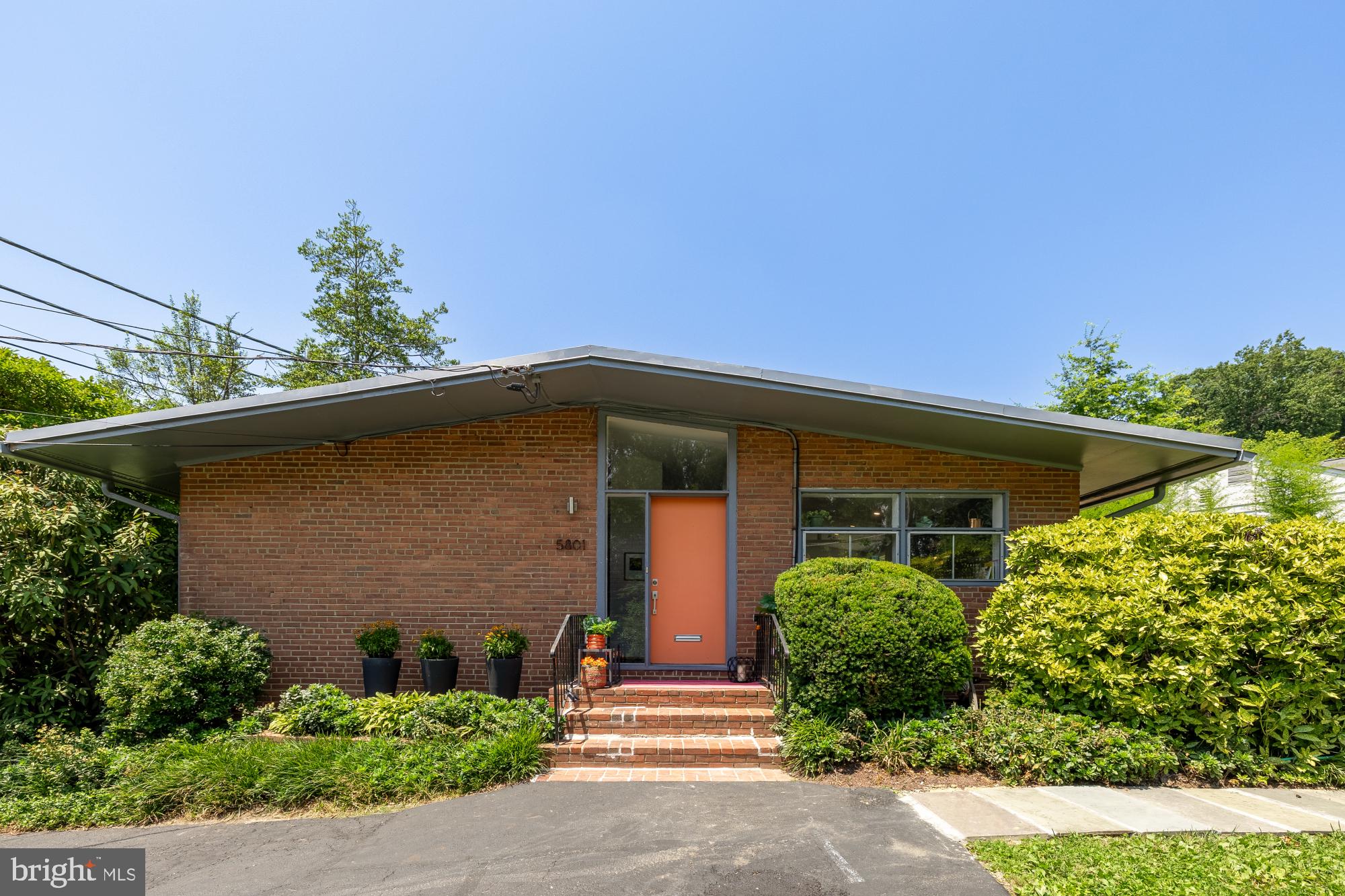 This mid-century modern home is a piece of history, designed by renowned architect Francis Donald Lethbridge, it has been lovingly preserved and thoughtfully upgraded. This 1952 treasure exhibits countless character defining elements and features of the modern era: vaulted ceilings, huge industrial-grade windows, clerestory windows, and 2 asymmetrical brick fireplaces (wood burning + gas burning). Skylights, floor-to-ceiling windows, and stretched horizontal windows span entire rooms to seamlessly bring nature into the home.
Spanning across 3,250 sq ft on 2 levels, there are 4 true bedrooms (with the opportunity for a 5th), 3 full bathrooms, and 5 other spaces that live as living rooms, dens, and bonus spaces. The kitchen, bathrooms, and the interior are freshly painted and the oak hardwood floors have been refinished. This mid-century modern home will transport you to a place of serenity and joy, making entertaining and daily living effortless.
This home features one of the largest lots that you will find in The Highpoint community.
A premium corner lot, it spans a quarter of an acre with mature and beautiful landscaping, perennial flowers, and flowering shrubs that bloom year round. There is a long, private driveway that allows for you to park over 3 cars. The backyard is a private and serene space with a large bluestone patio that overlooks the large flat grassy backyard that is framed out with a treescreen and flowering scrubs.
Coveted for its location, 5801 Mass Ave is at the crossroads of nature and city amenities! For nature, you have quick access to the Capital Crescent Trail for hiking and biking, The C&O Canal, the Potomac River, Glen Echo Park, and 2 parks within walking distance that have tennis courts, tot lots, and swingsets. And city amenities within 5-10 minutes include downtown Bethesda, the DC border and Spring Valley Shopping Center with Millies and other restaurants nearby, Glen Echo, The new Westbard Square, Sangamore Shopping Center, and access to the highway. Zoned to Wood Acres Elementary School, Pyle Middle School and Whitman High School. In boundary for the community members Mohican Swim Club!
Understanding the significance to this home’s architecture, Lethbridge’s most notable residential work, created the contemporary communities of Pine Spring, Holmes Run Acres, Potomac Overlook, and Carderock Springs around the metropolitan region, as well as multifamily projects Tiber Island and Carrollsburg Square Condos in DC. He also designed the master plan of Arlington National Cemetery and the River Road Unitarian Church close by.
Open House Sunday, June 29 from 2-4pm.