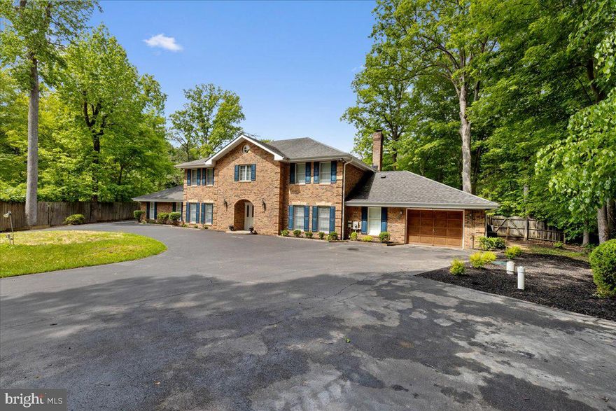 4 BR | 5 BA | 3,764 SQ FT | Nearly 1 Acre | Private Lakefront | Heated Pool | Private Dock

Located in the prestigious waterfront community of Shores of Calvert in Dunkirk, this stately all-brick Colonial offers timeless architecture, expansive living spaces, and over 200 feet of private lakefront on a tranquil setting designed for everyday comfort and upscale entertaining.

Set on a beautifully landscaped nearly one-acre lot, this custom waterfront home blends the enduring craftsmanship of classic Colonial design with the lifestyle amenities buyers seek in luxury waterfront real estate in Southern Maryland. A grand circular driveway, dual side-loading garages, mature trees, and panoramic water views create an impressive arrival experience from the moment you enter the property.

Inside, the nearly 3,800-square-foot floor plan balances formal elegance with relaxed waterfront living. The spacious great room serves as the heart of the home, featuring a wood-burning fireplace, custom built-ins, and large windows that frame peaceful lake views and fill the home with natural light.

The gourmet brick kitchen was designed with both functionality and character in mind, offering a wall oven, separate cooktop, walk-in pantry, wood stove, and generous prep space ideal for serious cooks, holiday gatherings, and entertaining guests. Just off the kitchen, the bright breakfast area overlooks the water, while the formal dining room provides an elegant setting for dinner parties and special occasions.

The home includes four generously sized bedrooms and five bathrooms, offering flexibility for guests, multigenerational living, or work-from-home needs. The primary suite serves as a private retreat with tranquil lake views and a spa-inspired en-suite bath featuring a classic whirlpool tub. Three bedrooms offer direct access to the expansive rooftop deck overlooking the lake, creating a rare outdoor living space perfect for morning coffee, sunset views, or evening gatherings under the stars.

Outdoor living is where this property truly shines. The backyard is designed as a private waterfront oasis featuring a heated in-ground pool, expansive patio, elevated balcony, lush gardens, and direct access to the lake. Launch a kayak from your backyard, spend afternoons fishing from your private dock, or enjoy peaceful evenings watching the water from multiple outdoor entertaining spaces.

Residents of Shores of Calvert also enjoy access to exclusive community waterfront amenities, including a shared pier and dock, adding to the appeal of this exceptional Dunkirk waterfront property.

This is a rare opportunity to own a classic luxury waterfront home in Calvert County, offering privacy, architectural character, resort-style amenities, and the kind of lakefront lifestyle that is increasingly difficult to find in today’s market.