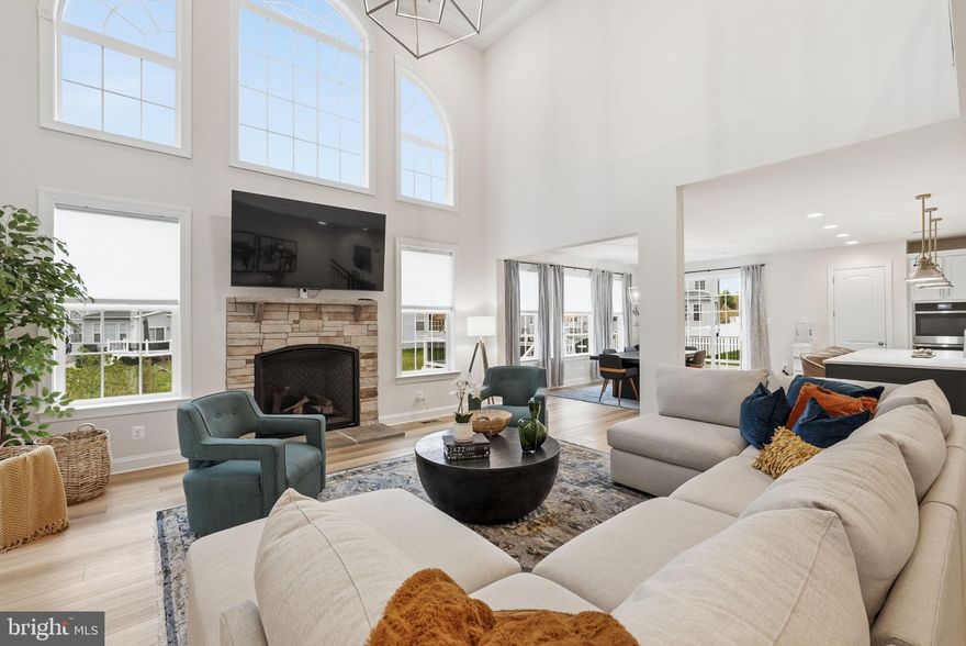 Stunning stone-front home tucked away on a quiet cul-de-sac, showcasing exceptional curb appeal with professionally landscaped grounds and elegant exterior lighting that creates a striking presence both day and night. A spacious two-car garage completes the impressive exterior.

Step inside to a grand two-story foyer highlighted by a dramatic waterfall staircase with modern contrasting finishes, setting the tone for the refined design throughout. The thoughtfully designed main level features a private office, formal living room, and dining room, offering both versatility and timeless appeal for everyday living and entertaining.

At the heart of the home, a breathtaking two-story family room is filled with natural light from expansive windows and anchored by a stunning fireplace. This impressive space flows seamlessly into the gourmet kitchen, creating an open and inviting layout ideal for gathering.

The gourmet kitchen is designed to impress, featuring a large quartz island with seating, stainless steel appliances, custom cabinetry, and designer pendant lighting. The open-concept design connects effortlessly to the main living areas, while a custom mudroom adds both convenience and functionality.

Upstairs, four spacious bedrooms include a luxurious primary suite with a tray ceiling, custom walk-in closet, and a spa-inspired bath complete with dual vanities, a soaking tub, and an upgraded walk-in shower with custom tilework and built-in seating. A secondary bedroom suite with its own full bathroom provides added flexibility, ideal for guests or extended living arrangements, while a buddy bathroom enhances convenience for additional bedrooms.

The fully finished basement expands the living space with a large recreation area, dedicated exercise room, and additional storage.

Outdoor living is equally impressive, featuring a stamped concrete patio with a built-in circular fire pit and raised stone seating wall, perfect for entertaining. An expansive composite deck overlooks a private wooded backdrop with mature trees, offering both privacy and tranquility, while outdoor lighting enhances the ambiance into the evening.

With 9-foot ceilings on all levels, energy-efficient systems, and quality craftsmanship throughout, this home offers a perfect blend of luxury, space, and functionality in a highly desirable location near commuter routes, shopping, dining, and everyday conveniences.