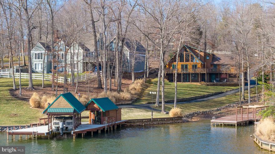 Welcome to an impeccable opportunity to own a custom log home on the public side of Lake Anna, Virginia. This one-of-a-kind residence features rare Hand-Hewn logs brought in from Montana, something rarely seen in Virginia, and expertly assembled to create this stunning custom-built retreat.

As you arrive, you are greeted by a long, beautiful private paved driveway offering plenty of space for parking, guests, and storage. From the moment you walk up to the home, you are immediately struck by the craftsmanship and presence of the grand log construction.

The home spans three finished levels.

Upon entering, you will immediately notice how bright and airy the home feels, enhanced by south-facing exposure overlooking the water, boathouse, and cabana. On the main level, you will find a stunning custom kitchen thoughtfully designed to face the lake, complete with high-end upgrades, custom fixtures, and grand A-frame windows that capture open water views. This level also includes the laundry room, a full bath, and a bedroom for convenient main-level living. Impeccably maintained, the kitchen flows seamlessly into an open-concept dining and seating area, perfect for entertaining. The large living room features expansive glass and direct access to the full wraparound deck overlooking the lake. The wraparound porch extends all the way to the lake side of the home, offering incredible space for entertaining. 

Upstairs, the loft offers even more breathtaking views through the A-frame windows. The primary suite is privately situated on this level and features a spacious bathroom and dedicated space for a home office overlooking the lake.

The lower walkout level is built for entertaining, featuring a bar and den area, an additional bedroom, and a full bathroom with a large jetted tub. The jets circulate air rather than water, eliminating buildup concerns. You will also find an immaculate mechanical room on this level. The bar area is hard-wired for speakers that extend through the bathroom and outside to the fire pit area, creating a fully integrated entertaining experience. Access the attached spacious 2 car garage from this level. 

This meticulously maintained home includes high-end fixtures and finishes throughout, including but not limited to: solid white oak hardwood floors, Dekton countertops, Vermont Castings wood-burning stove, LG washer and dryer, Bosch induction stovetop and dishwasher, LG electric and convection wall oven, two microwaves and custom lighting throughout. 

Stepping off the expansive decking and heading toward the water, you will find a paved path that connects to your private boat and jet ski launch, then winds down to the boathouse.

With approximately 150 feet +/- of shoreline, there is ample space to relax and enjoy lake life. Approximately 90 feet of shoreline is bulkheaded, offering enhanced erosion protection.

The expansive boathouse is positioned in approximately 9 feet of average water depth and features a spacious sun deck, along with a boat slip built with aluminum metal dock material and equipped with a lift.  A four-seasons cabana with WiFi that can be heated and cooled for year-round use. The cabana is wired for surround sound, includes a bar area, and offers incredible opportunities for waterfront entertaining. Enjoy outdoor living at its finest, whether watching TV in the boathouse with heat and AC, relaxing by the water, swimming off the dock, or heading out on the lake.

Located in the sought-after Wyndemere community, amenities include multiple boat launches, basketball courts, and more. High-speed internet is available. Short-term rentals are allowed. Newly performed appraisal has the home valued at $1,810,000! 

Optional boat purchase and furniture package available separately, negotiable. See attached MLS documents. View the 3D Tour and Video!