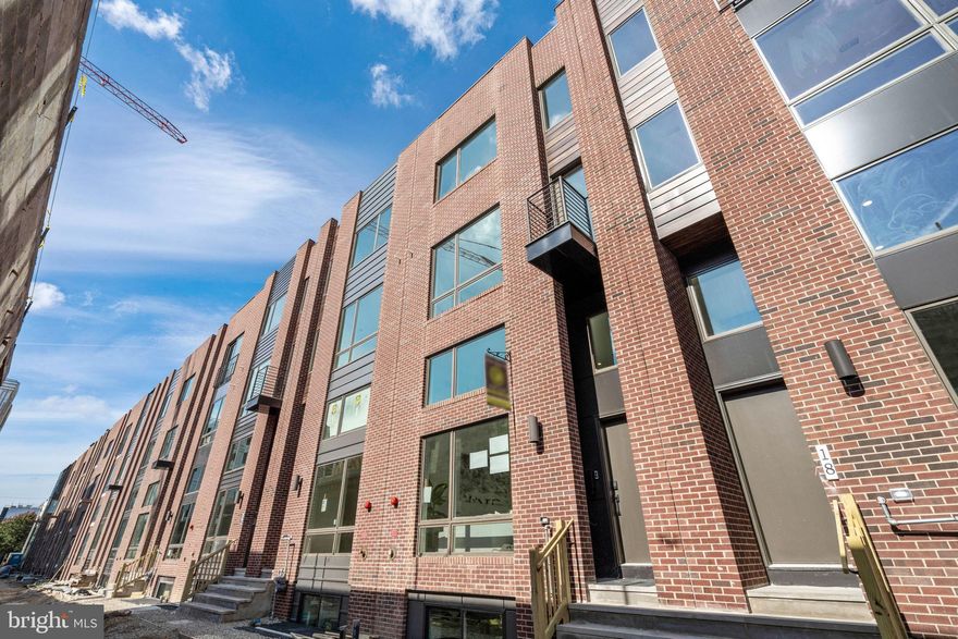 IMMEDIATE CLOSING AVAILABLE!!!  COMPLETED NEW CONSTRUCTION, FULL 10 YEAR TAX ABATEMENT!!! Luxury townhome with 2-car garage parking on the brand new League Way, a beautiful pedestrian-only green space!  This extra wide modern townhome at the former site of the Frankford Chocolate Factory presents a unique urban experience in close proximity to Center City, major transportation routes, universities, and hospitals. Boasting 3,200 total square feet of space, custom designed finish selections, and unmatched center city views. Go up the front steps into the expansive living room with 15 foot high ceiling and an open floor plan concept that leads you into the dining and kitchen area. The oversized dining area features a convenient half bathroom and flows into the gourmet chef designed kitchen. The kitchen features an oversized center island, quartz countertops, tile backsplash, stainless steel Cafe appliances that include drawer microwave, cooktop, double oven, and range hood. Exit the back of the kitchen to the rear deck that extends 8 feet off the rear wall: perfect for entertaining guests, outdoor grilling, and dining under the stars! Upstairs you will find two large bedrooms with large closets and a shared full bathroom. This floor is also equipped with a laundry room with gas washer and dryer and cabinets for storage. Continue to the top floor and enter the master bedroom suite with gorgeous center city views through the North facing windows. Continue down the hallway from the master bedroom to the walk-in closet that was meticulously designed to maximize space and efficiency. The master bath is wrapped in floor to ceiling tile and features a freestanding soaking tub, oversized shower room of seamless glass, a private lavatory, a double vanity, heated floors, and designer plumbing fixtures. Before you exit to the roof deck, there is a wet bar and sink conveniently located to entertain your guests as well as a half bathroom.  The roof deck is complete with green roof finishes and features spectacular panoramic views of the Philadelphia skyline. Special attention has been given to the rooftop design to maximize the usable space while enjoying the benefits of having a green roof. There is additional living space in the finished basement. Perfect for use as an office, workout/fitness room, or additional sitting area. If those features aren't enough, pull into the private paver driveway of this development and into your two car garage. These homes have a Ring camera system and have dual-zoned energy-efficient HVAC systems with NEST thermostats. metal handrails, recessed lighting throughout, and PELLA windows. Walk Score - 97, Transit Score - 100, Bike Score - 88. Conveniently located near Target, Sprouts Market, Whole Foods, Pet Smart, and on site CVS and Aldi on the way. 10 Year Tax Abatement. Taxes are estimated. Finishes shown in photos are of model home and may change or vary based on availability and builders discretion.