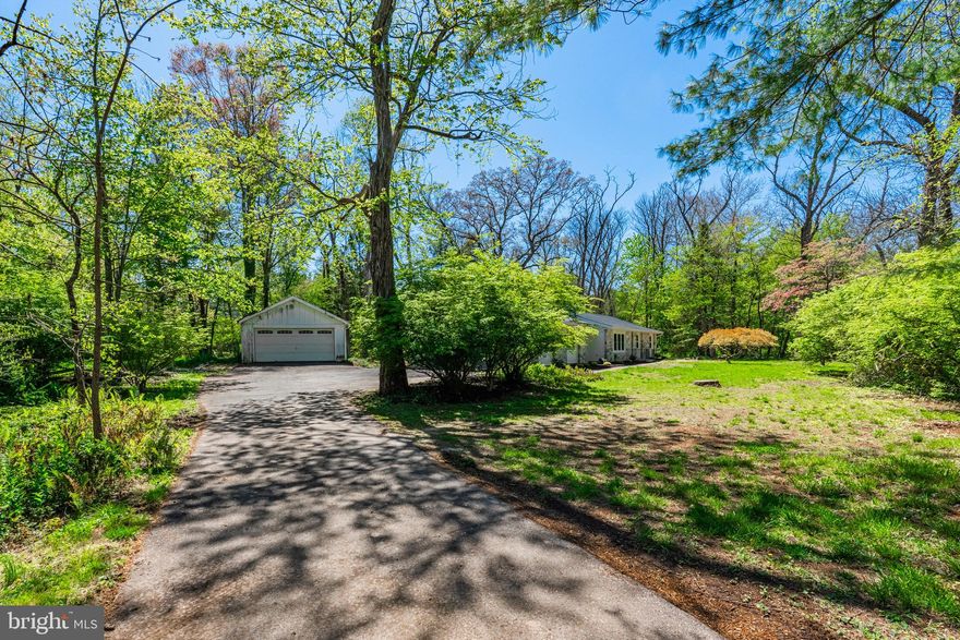 Nothing beats a visit to the creek on a nice day, unless of course, you have one on your property that you can visit anytime you like. 90 Morris Road offers just that, private Prophecy Creek views and access on over an acre of mature land. Located a stone’s throw from 90+ acres of preserved land, miles of trails and bustling downtown Ambler, this property can become your own private oasis. To top it off, you have the epitome of easy living on one floor in this renovated ranch home. To say that this is a rare opportunity is an understatement. Inside, you will love the open floor plan and bountiful natural light. You are welcomed by a spacious living room boasting a handsome floor to ceiling stone fireplace. The living room is open to the dining room, allowing for sight lines straight through the house, bringing the natural world in. The modern eat-in kitchen features quartz countertops, stainless steel appliances, plenty of storage and the all important, window over the sink. On the other side of the dining room, you will find a cozy sunken family room. This room is spacious, offering a large lounging area in the front of the house, and the rear section is segmented into a entry area mudroom with laundry hookup. This drop zone is very conveniently located, as it is just off the attached two car garage, as well as immediately inside the back door, off the driveway and patio. The opposite side of the house is where you’ll find your bedrooms and baths. The primary bedroom is spacious, featuring an ensuite bathroom and double closet. Two additional bedrooms are nicely sized and share the hall bathroom. The oversized attached two car garage offers so much more than parking space, as there is plenty of additional storage.  Out back, there is an extensive flagstone patio, ideal for summer barbecues and gatherings or just enjoying the sounds of nature while enjoying your morning coffee or an evening drink. If you are fond of our feathered friends, you’ll want to keep your binoculars handy, as this property offers an abundance; from song birds to woodpeckers, raptors and more, you will no doubt be delighted. The home sits back from the road and the driveway is very large, allowing for plenty of parking and turn-around. Extensive work has been completed in the past year including; renovated living space, updated kitchen and baths, the roofing system over the main house was rebuilt and a new roof installed, all new windows have been installed in the main house, new HVAC, updated electric and plumbing, and more. While so much has been done, there are still a few projects that remain, including some stone work around the patio and the detached garage. The detached two car garage needs repair and is being sold “as is” offering a fantastic opportunity to turn it into whatever your heart desires; a workshop, a funky she-shed, artist studio, or just additional parking and storage. Situated on a peaceful lot within the highly sought-after Wissahickon School District, this home combines comfort and style in a beautiful natural setting, minutes from everything you need. The restaurants, shops and festivals in downtown Ambler are less than one mile away. Spend your Saturday mornings at the Ambler Farmers market, while Weaver’s Way co-op fills the weekly void. Access to the train and gorgeous Wissahickon Watershed are some of the many other perks. 309, 202, and the turnpike are all minutes away, making your commute a breeze. Don’t miss 90 Morris Road, and when you visit, you may want to bring your binoculars; it is Spring migration, after all! Flood insurance is required if obtaining a mortgage.