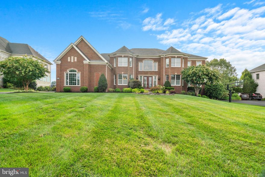 Step into a realm of unmatched luxury, where every detail has been meticulously crafted to perfection. This exceptional residence, built in 2013 by Toll Brothers, Inc. boasts expansive living areas adorned with high-end finishes, seamlessly merging elegance with comfort. From the lavish interiors to the stunning outdoor retreat set on over an acre of pristine grounds, this home is crafted to impress.

Mature trees provide a canopy of natural beauty and privacy, enhancing the picturesque views of the surrounding land. This stately colonial home boasts a timeless 100% brick exterior, exuding both durability and classic charm. The private driveway leads you to the impressive entrance- a meticulously landscaped pathway, flanked by lush bushes and neatly trimmed shrubs, guiding you to the home’s grand facade framed by double front doors that open to a sophisticated interior. 

Step into the grand foyer, where dual staircases make a striking first impression. On either side, elegant formal living and dining rooms feature hardwood floors and tray ceilings. The dining room’s textured wallpaper adds character, while the living room opens to a light-filled bonus room. Continue to the gourmet kitchen, connected to a cozy morning room. The study, behind French doors, offers a quiet retreat. The spacious family room, with its high patterned ceilings and floor-to-ceiling stone fireplace, is perfect for gatherings. Completing this level are a laundry room and two stylish powder rooms.

The eat-in kitchen is a chef’s paradise, featuring top-of-the-line JennAir® stainless steel appliances and elegant granite countertops. Equipped with a KitchenAid® dishwasher, a 6-burner gas range crowned by a custom range hood, a beverage center, an oversized island and breakfast bar, and a convenient prep sink, this space caters to both casual and gourmet cooking needs. Cherry cabinets add a touch of classic sophistication, complemented by the breakfast area, butler’s pantry, walk-in pantry, and built-in workstation. The adjacent morning/sun room offers deck access and picturesque views of the outdoors while basking in natural light. 

The owner’s suite is a true retreat, offering a spa-like ambiance with elegant tray ceilings and a spacious sitting area complete with granite countertops, built-ins, and a JennAir® beverage refrigerator. The suite also features two generous walk-in closets and a stunning en suite bathroom, which includes a center jetted soaking tub, dual vanities, and a large glass-enclosed shower with a built-in bench. On the upper level, you'll find three additional bedrooms. Two boast private sitting areas and walk-in closets and all have attached full bathrooms.

The fully-finished lower level is an entertainer’s dream, featuring an expansive open recreation room that opens directly to the patio. The space includes a full wet bar with granite countertops, a beverage refrigerator, a dishwasher, custom built-ins, and a dedicated storage area with a built-in wine system. Additional highlights include a convenient powder room, an exercise room with gym-quality flooring, and a theatre room equipped with built-in riser seating, a projector, and a screen for the ultimate movie experience. A welcoming guest suite on this level offers a walk-in closet and a private full bathroom. The additional unfinished space provides a blank canvas or ample storage options.

Enjoy outdoor dining and entertaining in style on the composite deck, which steps down to a breathtaking paver patio. This spacious, fully fenced yard features a charming gazebo, a fire pit, a tranquil pond feature, and a built-in garden. The yard is beautifully lined with mature trees, providing shade and privacy for a serene and picturesque setting.

The Preserve at Triadelphia Ridge offers access to scenic parks, golf courses, and equestrian trails, all set within a serene, picturesque countryside with stunning views conveniently close to shopping and dining options.