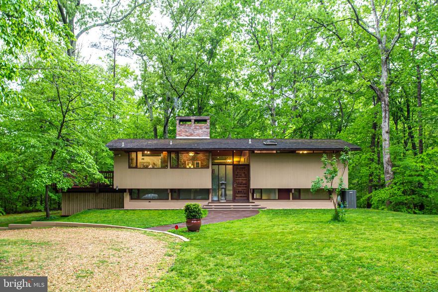 Unique opportunity to own this very special contemporary Deck Home designed by a student of Frank Lloyd Wright’s type of architecture! Constructed with tongue and grove western red cedar siding, Post and Beam construction and double pane custom windows, the Original owners have lovingly cared for and updated this one-of-a-kind beautiful home with so many special designs, features and finishes. It’s both energy efficient and beautiful as it was thoughtfully planned out to take advantage of the design and the natural setting. Peace and serenity abound here in your very private oasis. Gorgeous, spacious and sturdy (partially covered) deck wraps around this home for enjoyment of the nature around you, there is even a stream on the property. The abundant windows take advantage of the scenery as well, enhancing your living experience with nature from the inside as well as the outside. Recessed soft LED lighting (with controlled dimmers) will give you plenty of ambience in the great room with beautiful 11’ cedar ceilings, as well as the brick double-sided fireplace.  The kitchen was remodeled and updated 3 years ago, with quartz countertops, cherry cabinetry, and stainless steel appliances and many space saving features, as well as a double oven type of range! There are two generously sized bedrooms on the main level. The beautifully designed bathrooms were updated and upgraded as well. There are hardwood floors throughout and mahogany trim and cedar ceilings with Douglas fir beams. The lower level family room features a second fireplace with woodburning stove, a motorized 100” screen and projector system with surround sound that conveys with property, and built in shelves. There are also 2 more bedrooms and a full bath on the lower level. Huge storage area is featured under the foyer and there is a utility room/area on the lower level. This home shows light and airy, taking advantage of natural light with the many custom windows throughout.  There is a 3 car oversized garage with 9’ doors, electricity and water.  All of this on 2.85 acres. You can have this outstanding quiet setting, yet still an easy commute to Washington DC, Joint Base Andrews, the National Harbor and points south. Don’t miss this opportunity – come take a  look – won’t last!!