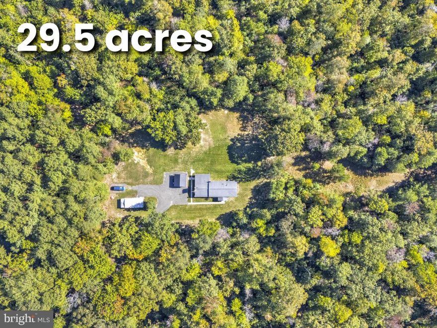 Nestled on 29.5 acres of serene, wooded privacy, this exceptional estate offers a rare blend of character, modern updates, and endless potential. Inside the 2,700+ sq ft home, you’re welcomed by distinctive features like a striking cedar beam and dual staircases that add warmth and architectural charm. The spacious kitchen is a standout, featuring granite countertops, stainless steel appliances, tile flooring, and abundant cabinetry—perfect for both everyday living and entertaining.

The home offers generously sized bedrooms, an updated guest bath, and a luxurious owner’s suite complete with a walk-in closet and a beautifully renovated en-suite with floor-to-ceiling tile and a walk-in shower. The main level provides multiple gathering spaces, including a formal dining room, a large family room, and a unique all-season room filled with natural light.

The finished basement expands your living space with a cozy wood stove, three additional bedrooms, and a fully updated bathroom—ideal for guests or flexible living needs. Outside, two open field areas offer endless opportunities for recreation, gardening, or even horses, while the detached workshop with its own 200-amp service is perfect for hobbies, storage, or projects.

With major updates including a newer roof, HVAC system, well pump, and hot water heater, this home offers peace of mind along with its natural beauty—all just minutes from shopping, dining, and Pax River.
