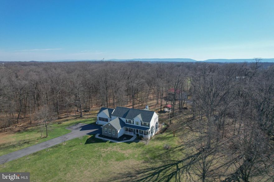 Set on 3.55 acres in the prestigious Preserve at Barleywood, this exceptional estate offers nearly 5,000 finished square feet designed for today’s modern living needs—where luxury, flexibility, and functionality come together seamlessly just minutes from Charles Town and within reach of Northern Virginia commuter routes.

This 5-bedroom, 6.5-bath residence is thoughtfully designed for multi-generational living, featuring a fully integrated in-law suite that lives like a private residence of its own. The suite includes a full bedroom, accessible bath with walk-in shower, widened doorways, seamless low-maintenance LVP flooring, a full KitchenAid appliance package, efficiency kitchen, private laundry, and dedicated living and dining space—ideal for extended family, guests, or long-term flexibility.

Beyond the suite, the main home unfolds with a classic, welcoming design and over 4,000 square feet of expansive living space. A bright, open foyer sets the tone, leading into a dramatic two-story living room with soaring windows and a wood-burning fireplace. The kitchen is both functional and beautiful, featuring a gas range, granite countertops, center island, rich wood cabinetry, and an extended sunroom dining area that captures sweeping views of the surrounding landscape.

Additional main-level spaces include a formal dining room and a flexible sitting room or office, all anchored by hardwood flooring throughout. The upper level offers generously sized bedrooms, including a spacious primary suite designed for comfort and retreat.

The home also includes a massive unfinished basement, offering incredible potential for future expansion—whether envisioning a home theater, fitness space, additional living quarters, or recreation area.

Step outside and the property truly becomes something special. The outdoor living experience is designed for both relaxation and entertaining at scale. A 20x40 in-ground pool is surrounded by extensive hardscaping, complemented by a two-tier composite deck overlooking the space. The pool house is fully equipped with bar seating, lounge area, and a full bathroom, creating the perfect setting for gatherings that carry from day into evening.

The grounds offer multiple areas to dine, entertain, and unwind, including a covered fire pit area ideal for quiet nights and storytelling. Practicality meets lifestyle with abundant storage, including space beneath the deck, a 10x12 shed for tools and pool equipment, and an impressive 30x50 pole barn with RV-height door—perfect for hobbyists, business use, or recreational storage.

A double driveway with lighting extends to the rear of the property, complete with RV electrical hookup and additional parking near the pole barn, offering flexibility rarely found in residential settings.

Significant system upgrades provide peace of mind, including three HVAC systems (recently replaced), a new mini-split in the pool house, updated septic field, new well pump (2020), whole-house water treatment system with reverse osmosis, UV light, and filtration, a 1,000-gallon propane tank, and a new roof with 50-year architectural shingles.

This is more than a home—it’s a private retreat, an entertainer’s dream, and a solution for evolving living needs, all within one of Jefferson County’s most sought-after communities.

For buyers searching for space, versatility, and a property that truly delivers on both lifestyle and location, 140 Parliament Way stands in a category of its own.