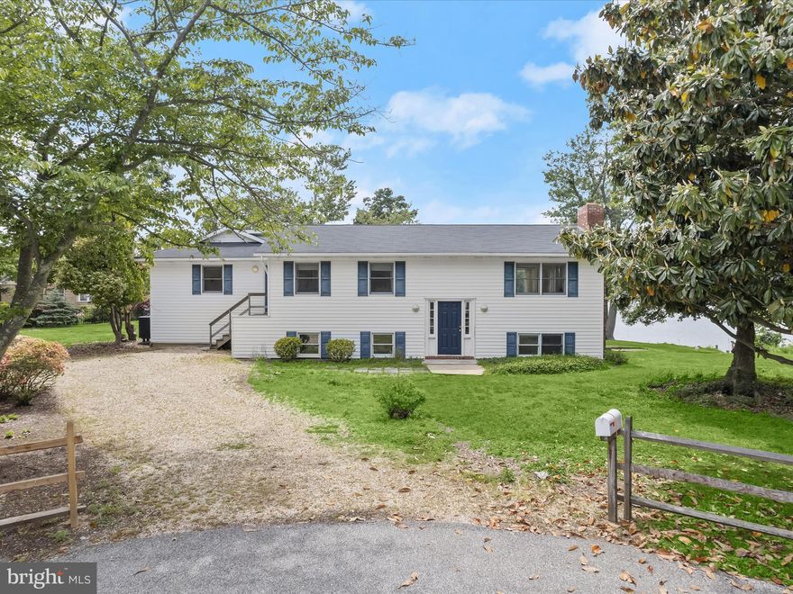 Nestled at the end of a quiet cul-de-sac and set on over half an acre, this rare waterfront opportunity on Mill Creek offers stunning panoramic views, tranquil privacy, and a lifestyle centered around the water. With a deep-water pier, a dock with a single slip, and a mean low water depth of 8 feet, the property can comfortably accommodate 80 foot vessels making it a dream for serious boaters and waterfront enthusiasts alike. The home is filled with potential, waiting for your vision to make the most of its prime setting. Hardwood floors flow throughout the main level, which includes a spacious living room with a fireplace and a large dining room just off the kitchen. The kitchen enjoys its own water view and is enhanced by sliding glass doors that open to the expansive deck, perfect for morning coffee or entertaining against a backdrop of sunrise skies over the creek. One of the standout features is the sunroom, with floor-to-ceiling windows that flood the space with natural light and offer uninterrupted water views year-round. At the far end of the home, the primary suite addition is a retreat of its own, complete with an en-suite bath, walk-in closet, and a few steps down to a dramatic sitting room with a two-story ceiling and a second fireplace. Sliding glass doors in both the bedroom and sitting room provide easy access to the deck and backyard, creating a seamless indoor-outdoor connection.
The lower level includes three additional bedrooms and a full bath, along with a laundry room and utility space. Mature landscaping surrounds the home, and a backyard shed provides extra storage.
Located in a sought-after waterfront community, this home offers convenient access to shopping, dining, marinas, and recreation. Mill Creek flows into the Chesapeake Bay, offering easy access to the Severn River and Downtown Annapolis, delivering the quintessential Annapolis boating lifestyle. This is an estate sale with key documents already in hand and ready for review. Whether you’re an investor, renovator, or hoping to create your dream waterfront retreat, this is a rare chance to secure a prime piece of Mill Creek shoreline.