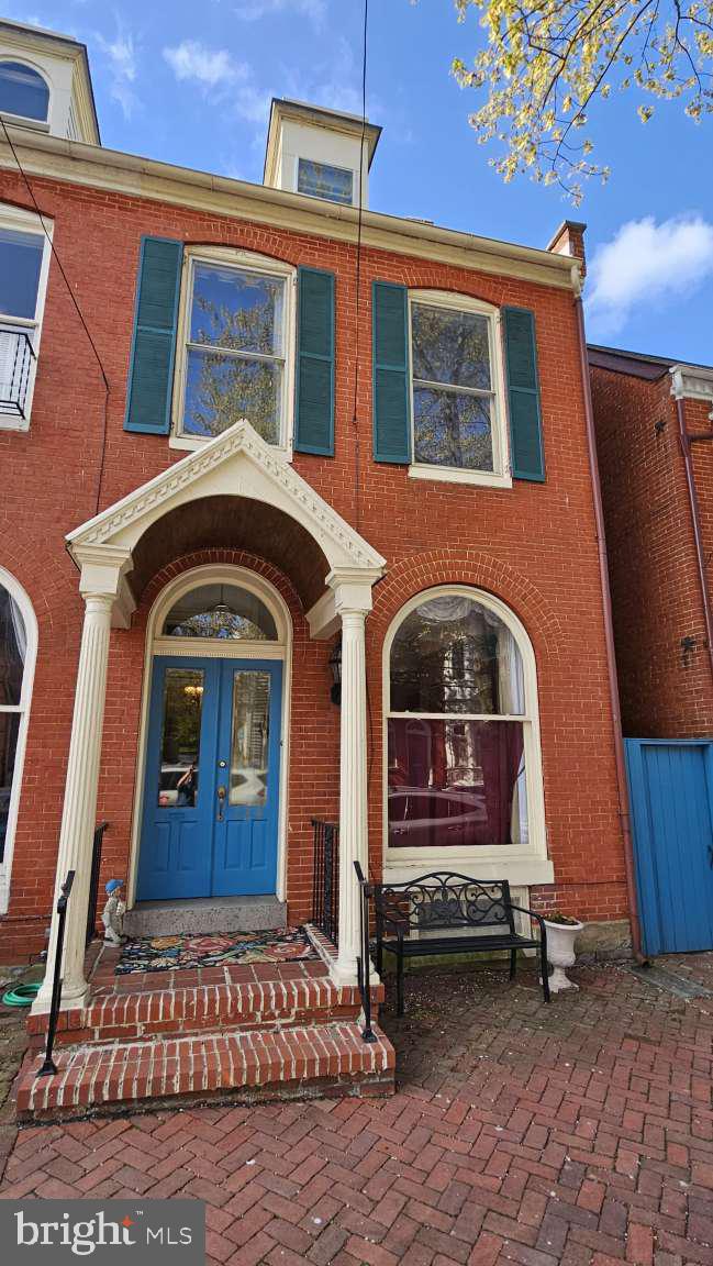Perfect Historic Downtown Frederick location ½ block from Baker Park and 2 blocks to Market Street! It has an incredible mix of historic Victorian quality and details with elegant modern upgrades in this duplex townhouse. Twelve-foot ceilings on the first and second floors and an enormous front window with new period draperies set the scene. Four fireplaces, two with electric fireplaces gorgeous King of Prussia marble mantels from the original Ross/Mac Mathias House set the tone downstairs. Other architectural features include original wood floors in most rooms, hand crafted woodwork, coffered ceilings, transoms and crown, picture and chair molding, original Victoria hinges, pocket door, etc. In 2023 owner installed: brand-new kitchen with matching countertops, restored hardwood floor and SS appliances and voluminous cabinet and pantry spaces; repaired the chimneys, and added a native plant garden and fire pit seating area with brick walkway to rear gate. Second floor boasts three bedrooms large enough to comfortably fit king-size beds and a laundry closet so all those clothes don’t have to go far and a balcony off the back bedroom. Full bathrooms on each floor; split HVAC systems. Finished attic boasts windows on three sides and can be used for an additional bedroom or two. Unfinished basement underlies it all for extra storage or future growth potential. Zoned DBO, Downtown Business Office, allows you to use as a home or professional office. Don’t miss this opportunity! Resident Parking Permit makes street parking easy or take on rent of a parking spot in the lot behind the back gate! Join the list of important Frederick residents who have owned this home.