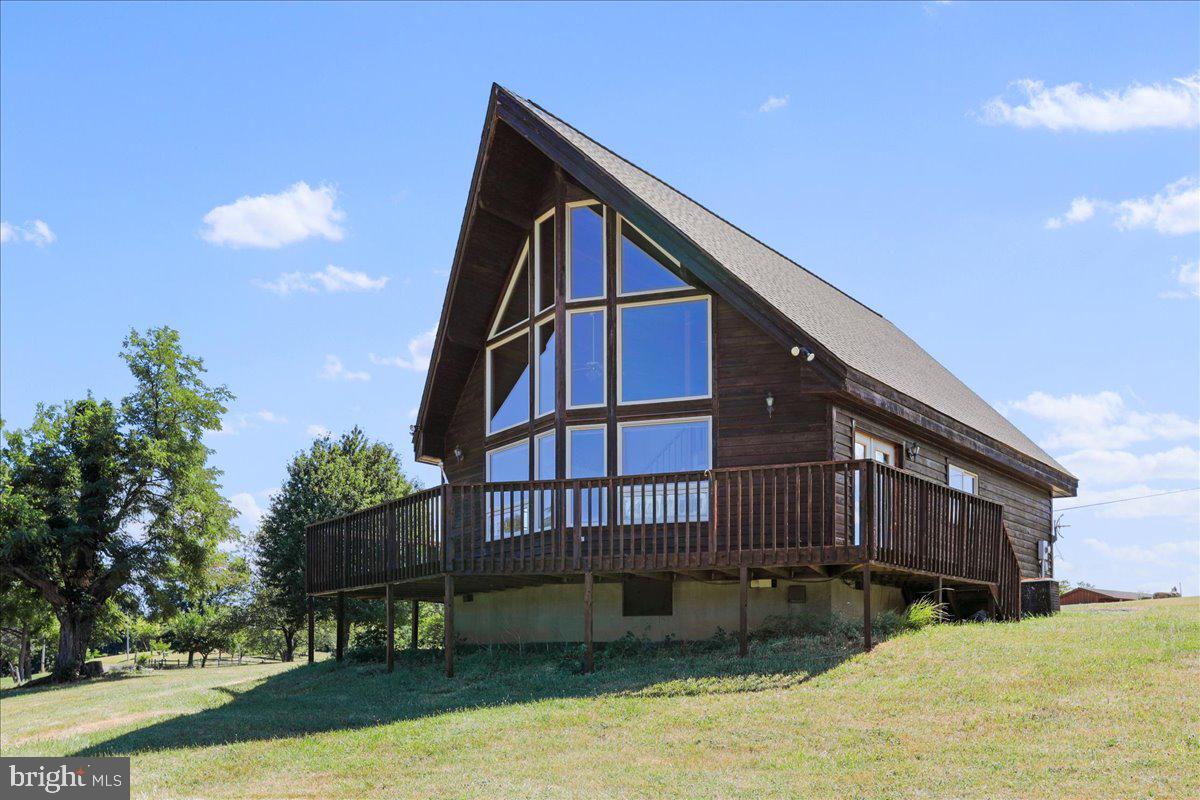 When only the real McCoy will suffice, welcome to your dream retreat in Hampshire County, West Virginia! Nestled at an impressive 1,600 feet in elevation atop a picturesque mountain, this stunning Lindal Cedar Home offers over 1,373 square feet of pure rustic charm on a sprawling 15.80 acres. With 3 spacious bedrooms and 1 full bathroom, this mountain sanctuary is perfect for those seeking tranquility, breathtaking views, and a profound connection to nature. Crafted with meticulous attention to detail, this home exudes rustic class. The warm, inviting interior features exposed wooden beams, oversized windows, and an open living area, creating a welcoming atmosphere perfect for year-round comfort. The three generously sized bedrooms provide ample space for family and guests, ensuring everyone can wake up each morning to the serene sights and sounds of nature right outside their window. The crown jewel of this mountain retreat is the panoramic western view, offering an unparalleled spectacle of West Virginia’s natural beauty. Whether you're sipping your morning coffee on the expansive deck or watching the sunset from the cozy comfort of your living room, the vistas from this property are nothing short of spectacular. Set on a generous plot of land, this home offers endless opportunities to explore the great outdoors. Hike, bike, or simply enjoy a leisurely stroll through the surrounding woods. The property is a haven of natural beauty and wildlife, providing a peaceful retreat from the hustle and bustle of daily life. Additionally, the property features numerous fruit trees, including pears, apples, peaches, plums, and cherries of different varieties. Situated at the heart of outdoor recreation and close to several public access points to the South Branch of the Potomac River, it serves as the ultimate launching point for your adventures. Despite its secluded feel, this idyllic oasis is conveniently located within an easy two-hour drive from the nation's capital, Washington, D.C. This rare blend of tranquility and accessibility makes it the perfect spot for a peaceful retirement retreat, a vacation home, or a year-round residence. Opportunities to own a treasure like this are quickly disappearing. Don’t delay—secure your piece of heaven on earth today. Experience the real McCoy of mountain living and make this enchanting Lindal Cedar Home your own.